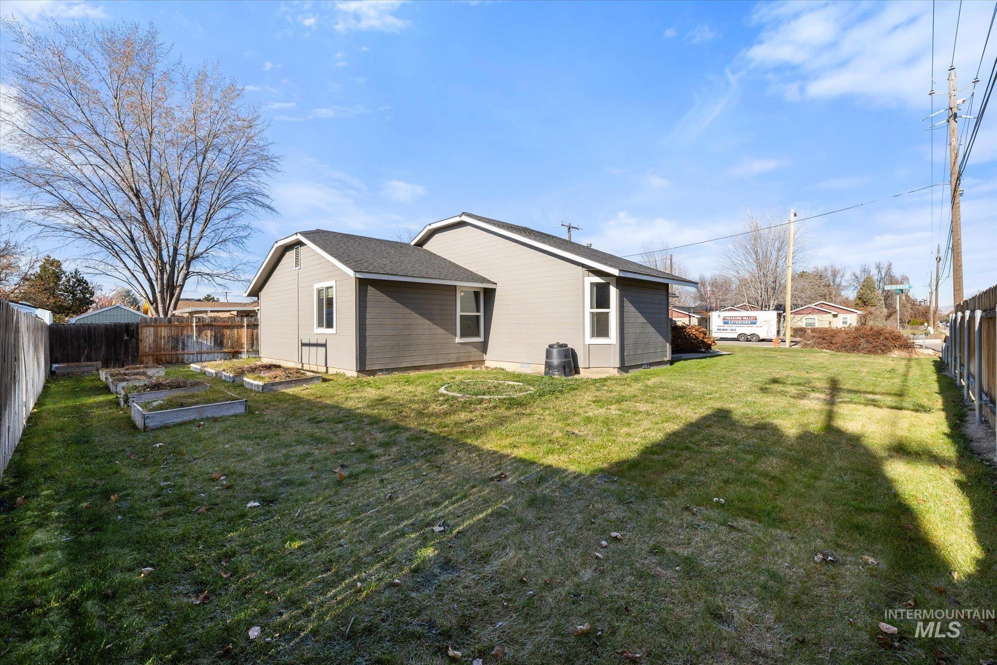 Rear view of house featuring a vegetable garden and a fenced backyard