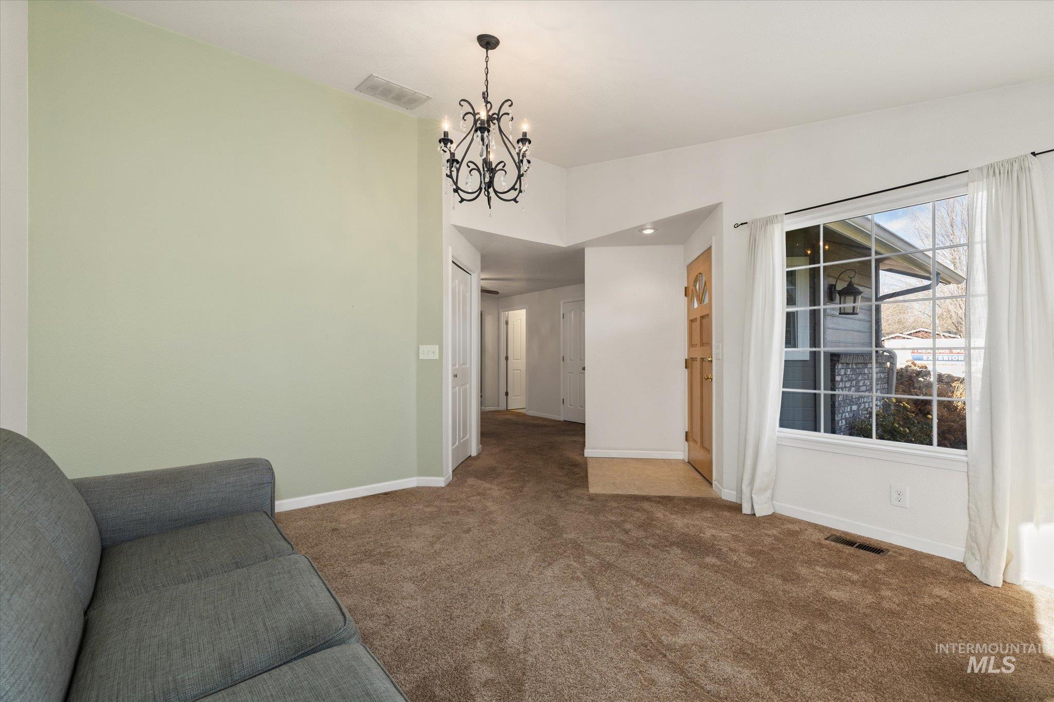 Living area with a chandelier and carpet floors