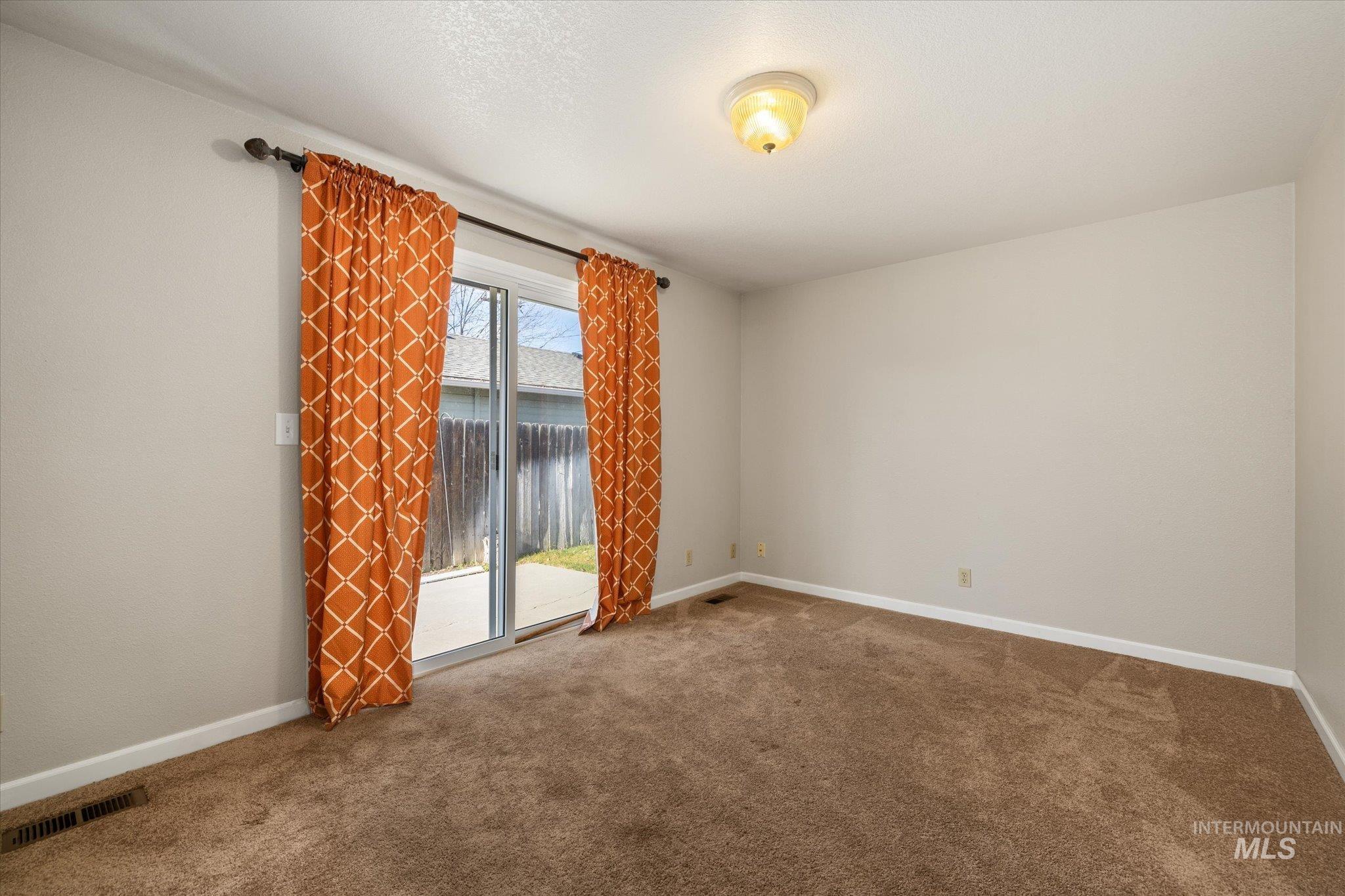 Carpeted empty room featuring baseboards