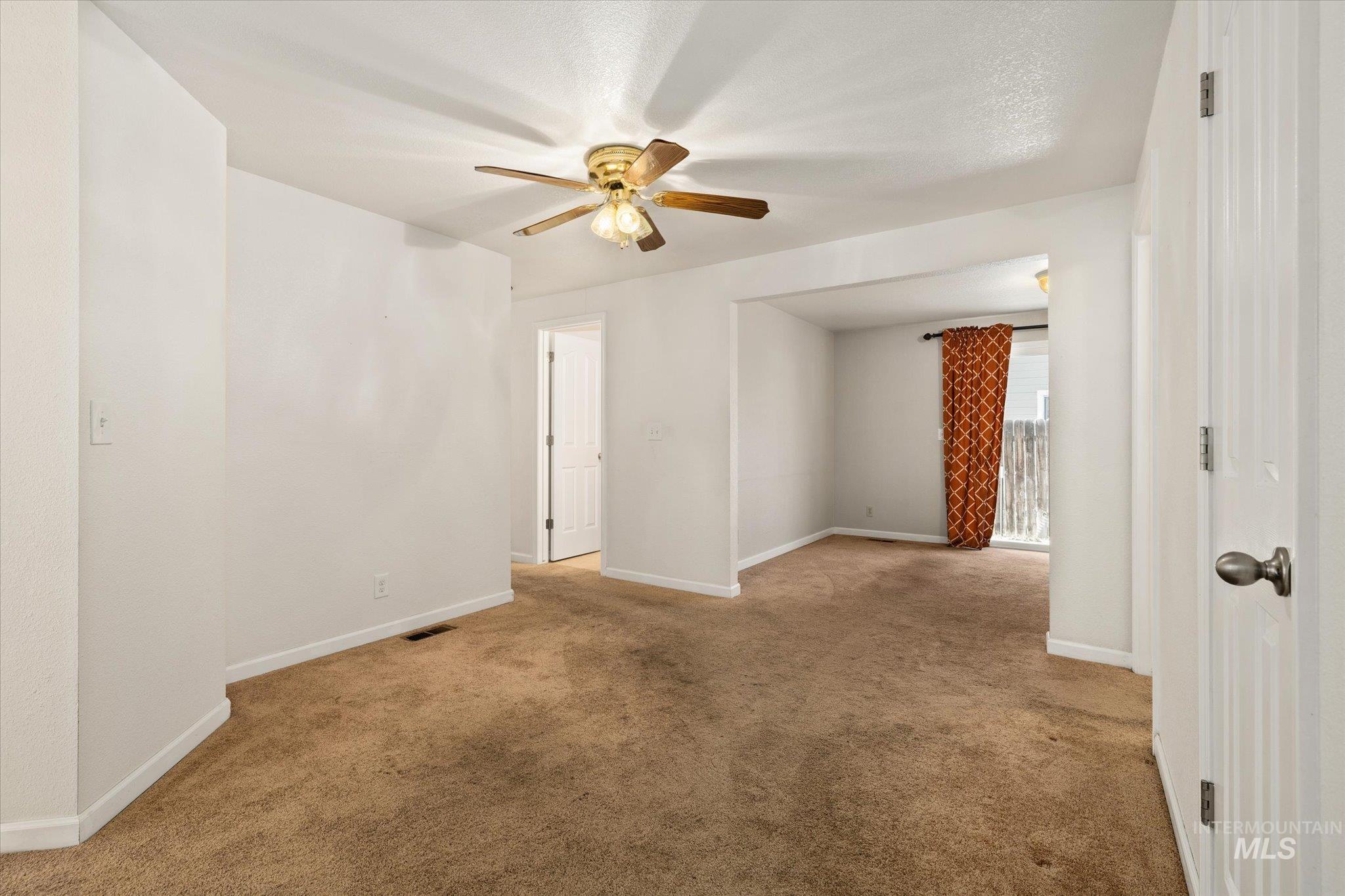 Spare room with light carpet and ceiling fan