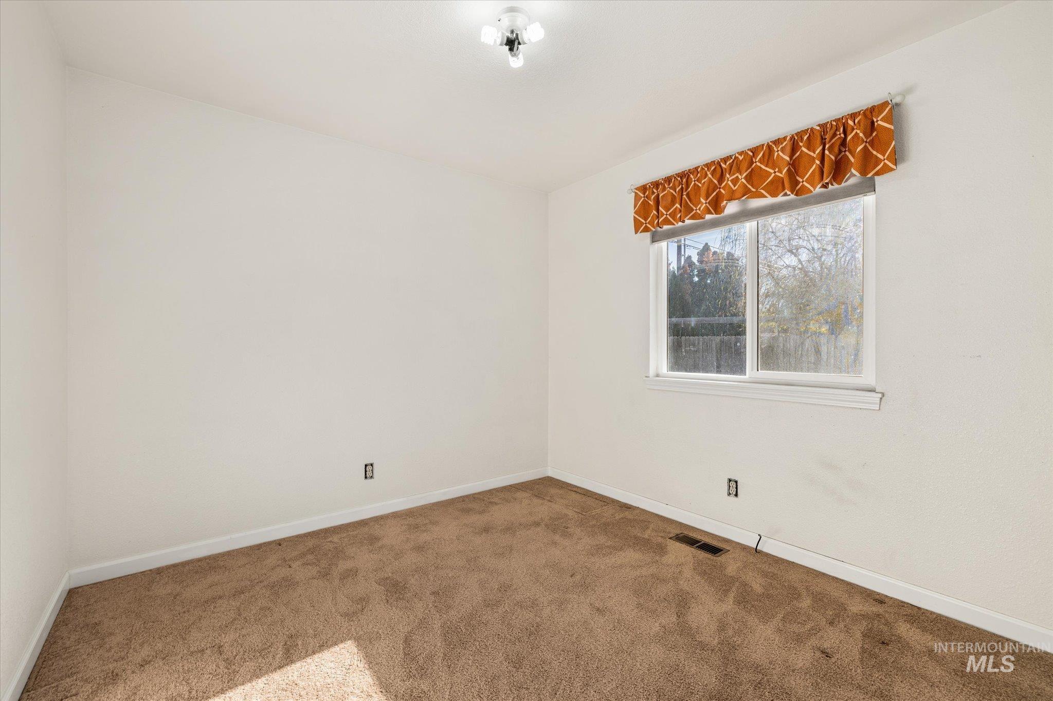 Carpeted empty room with baseboards