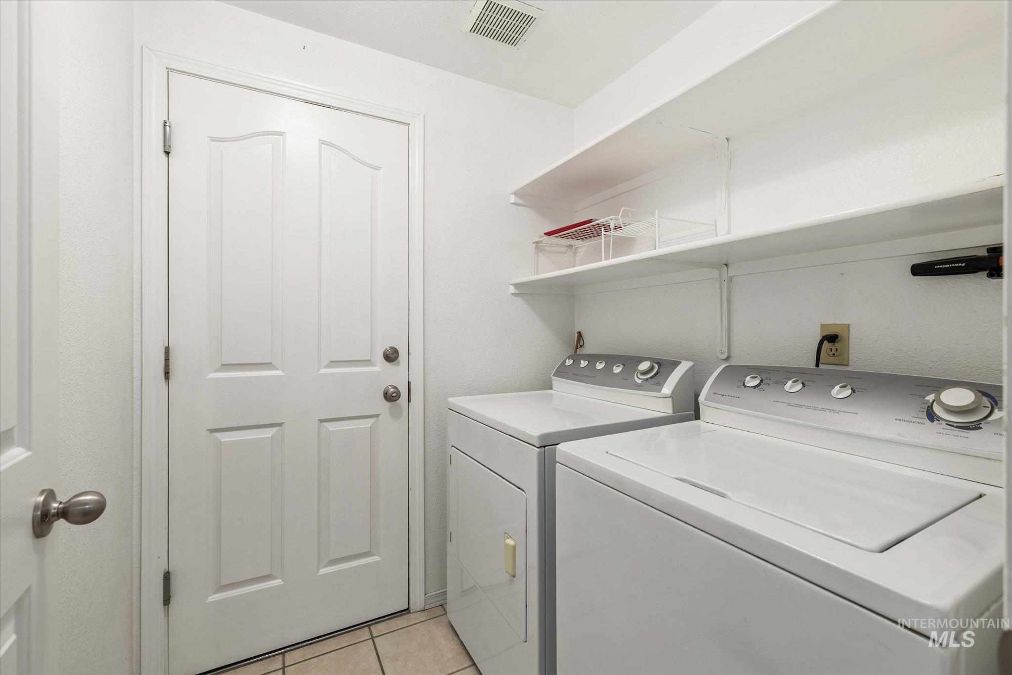 Laundry room featuring light tile patterned flooring and separate washer and dryer