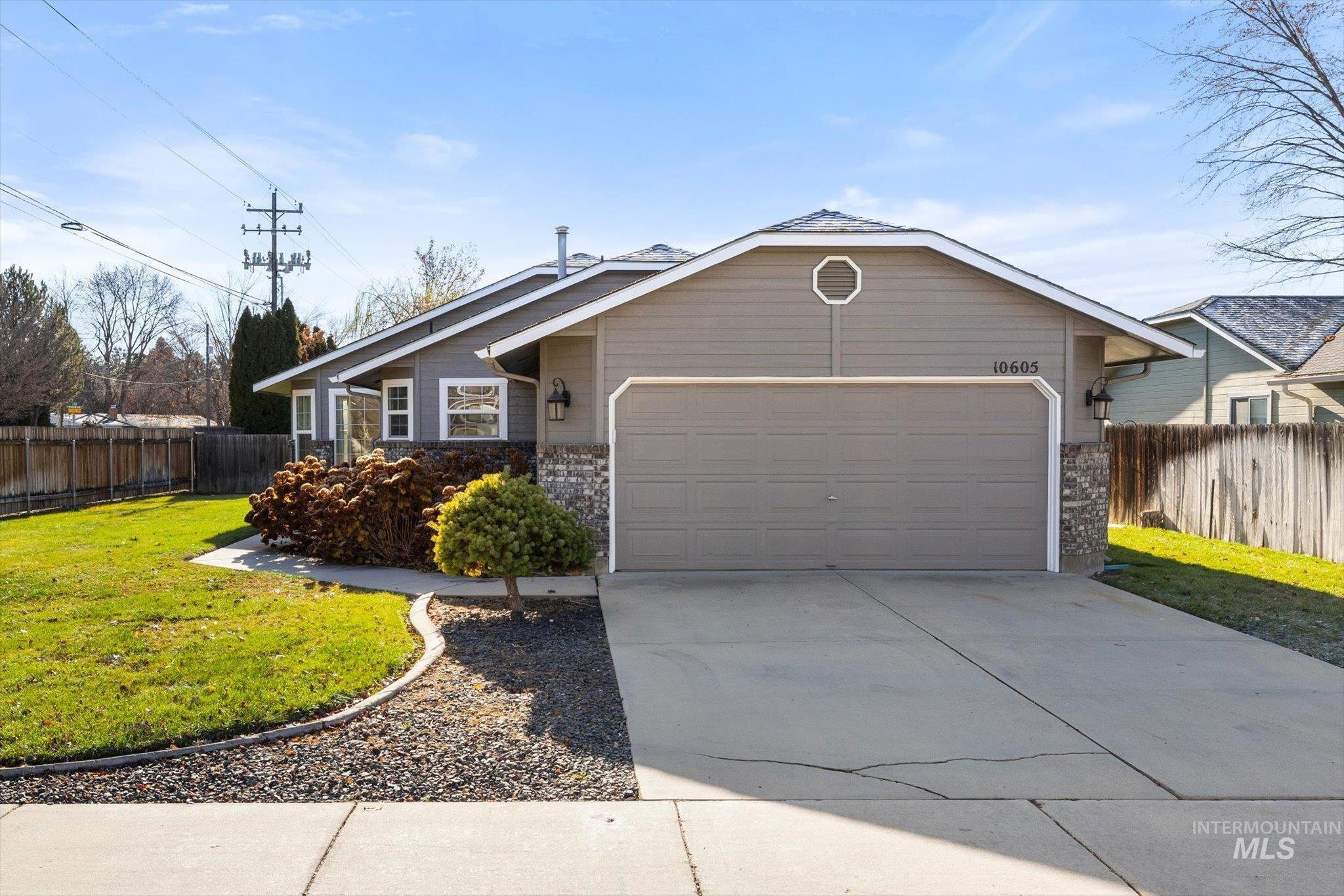 Ranch-style house with concrete driveway, a garage, and stone siding