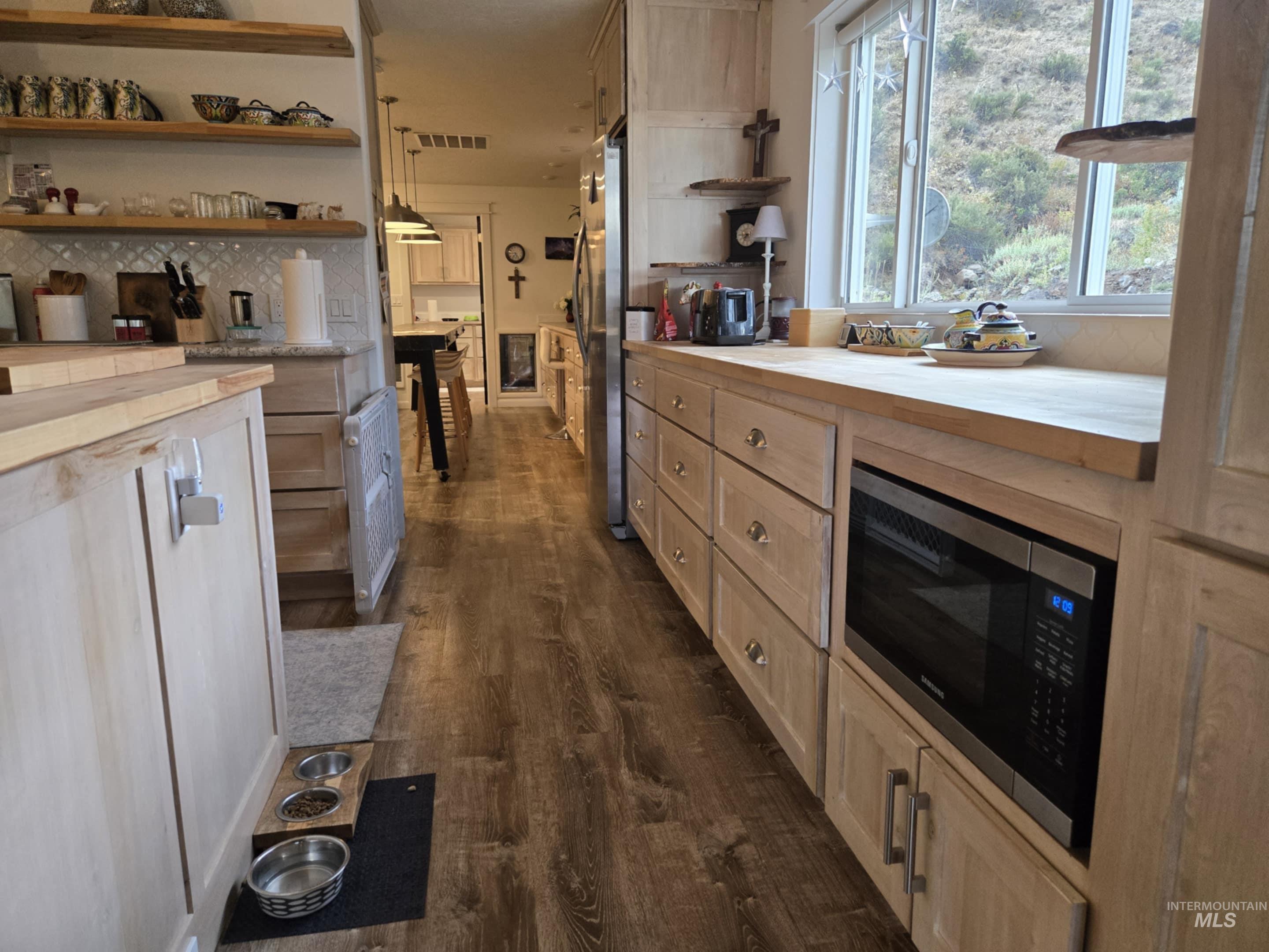 More butcher block countertops extend the workspace, while a second refrigerator adds convenience. Just beyond, a dedicated craft room with its own perfect crafting table