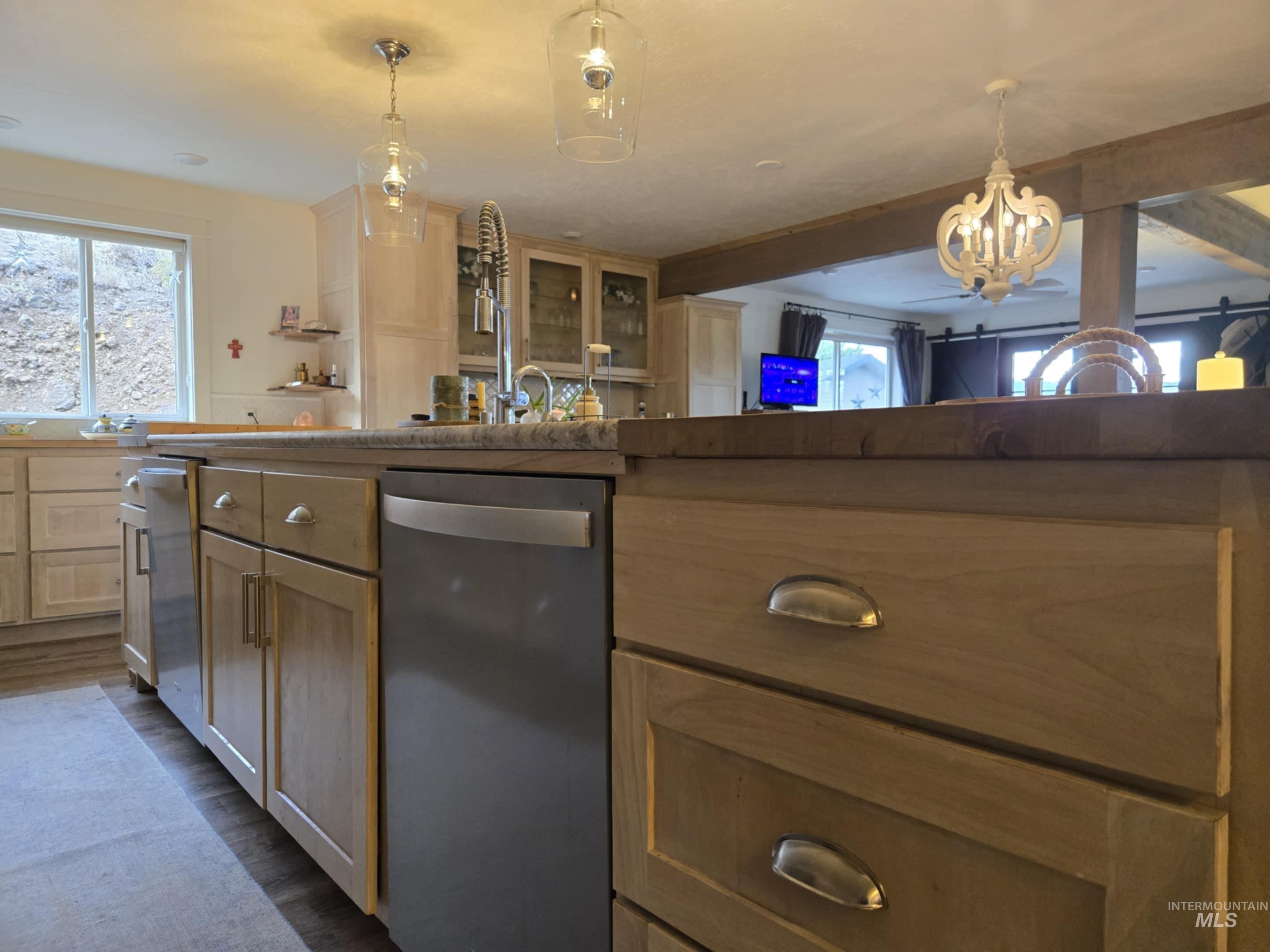 The oversized island does more than anchor the kitchen it houses two dishwashers, incredible storage, and plenty of room on the other side for your favorite people