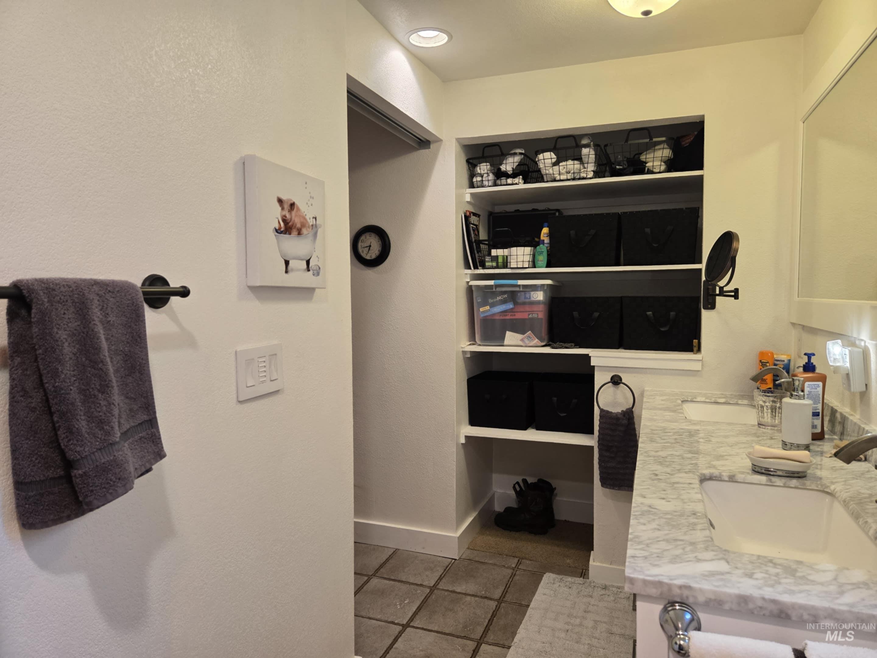 The primary bathroom features open shelving, keeping essentials close at hand while adding a stylish, airy feel