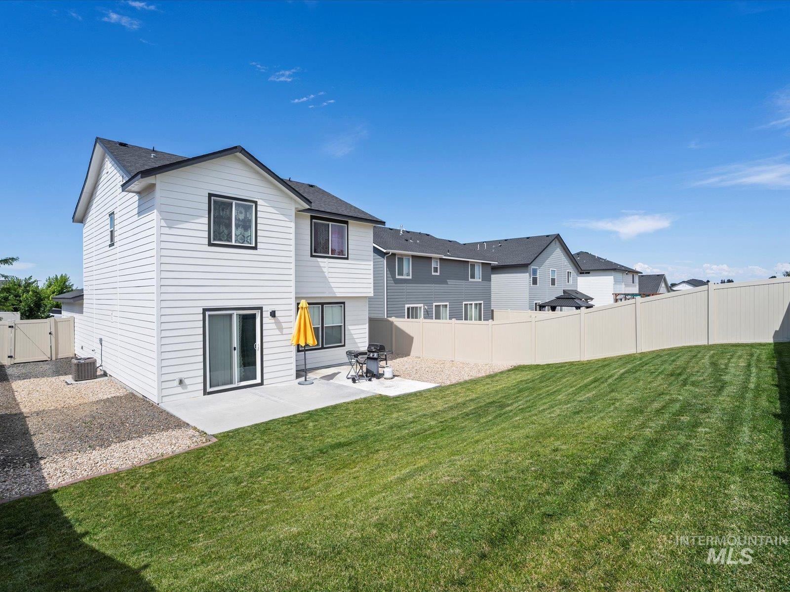 Back of house featuring a patio area, a gate, a fenced backyard, and a residential view