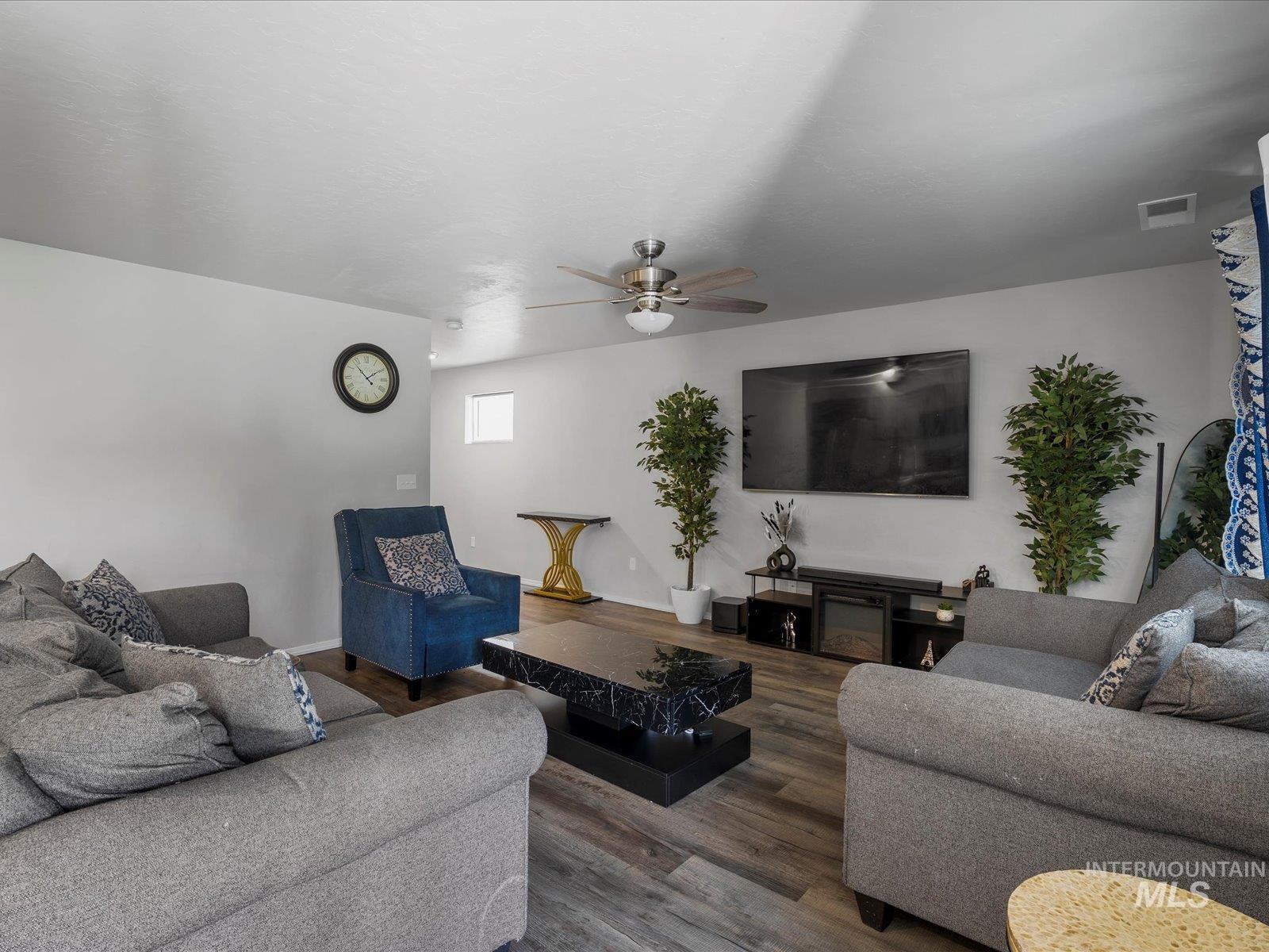 Living area with ceiling fan and wood finished floors