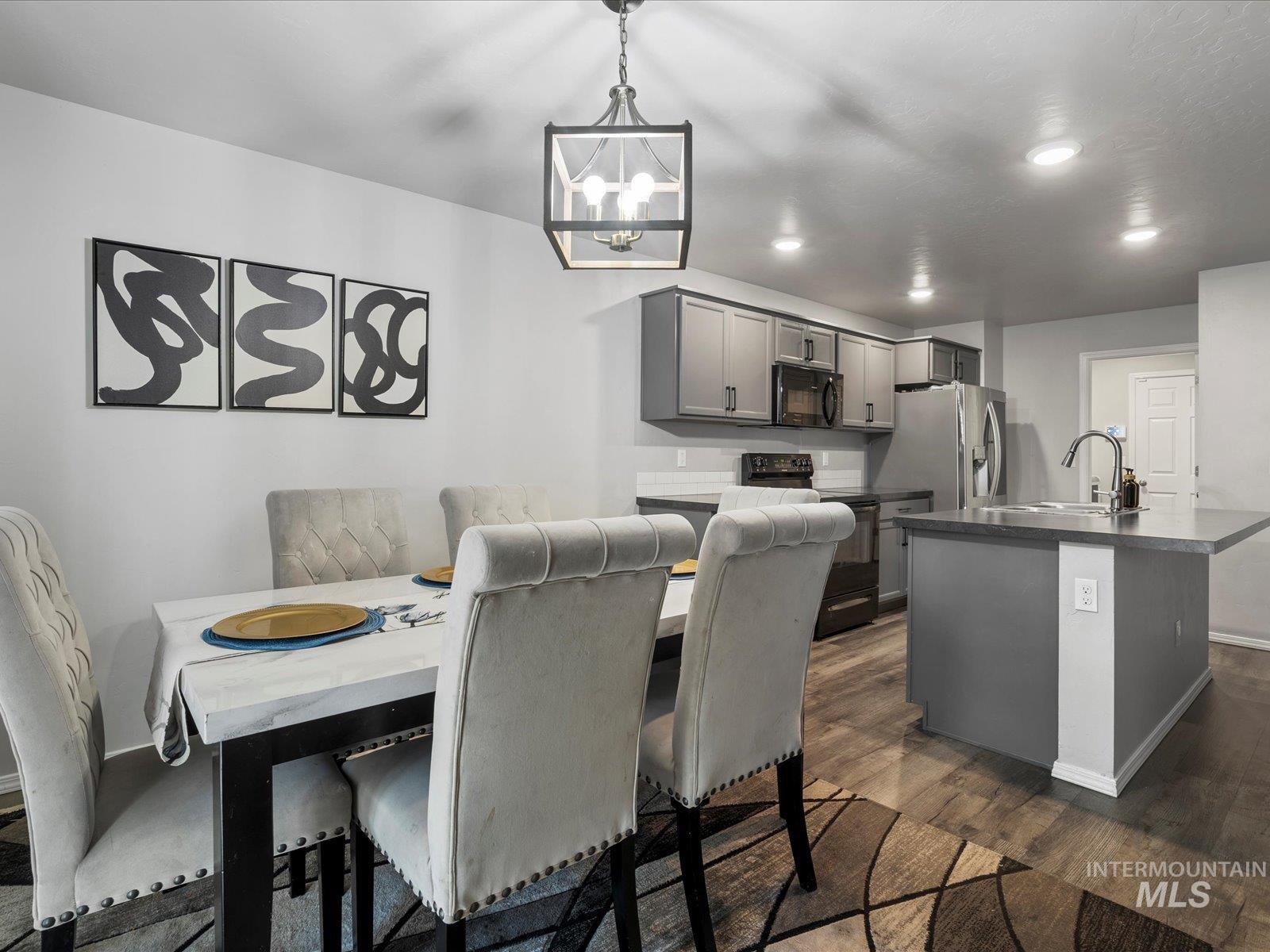 Dining space featuring dark wood-style flooring, recessed lighting, and a chandelier
