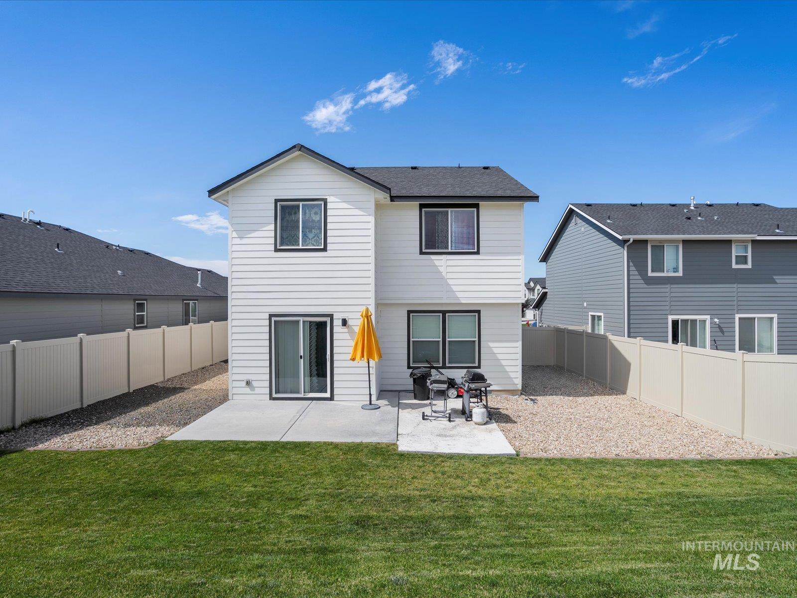 Rear view of house with a patio and a fenced backyard