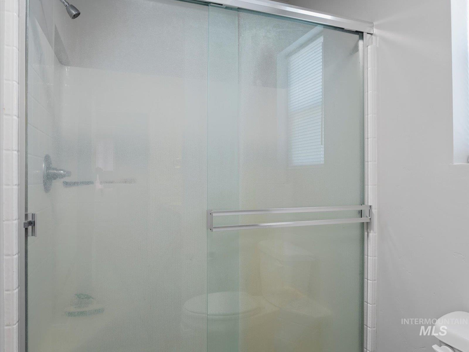 Full bathroom with toilet and a stall shower