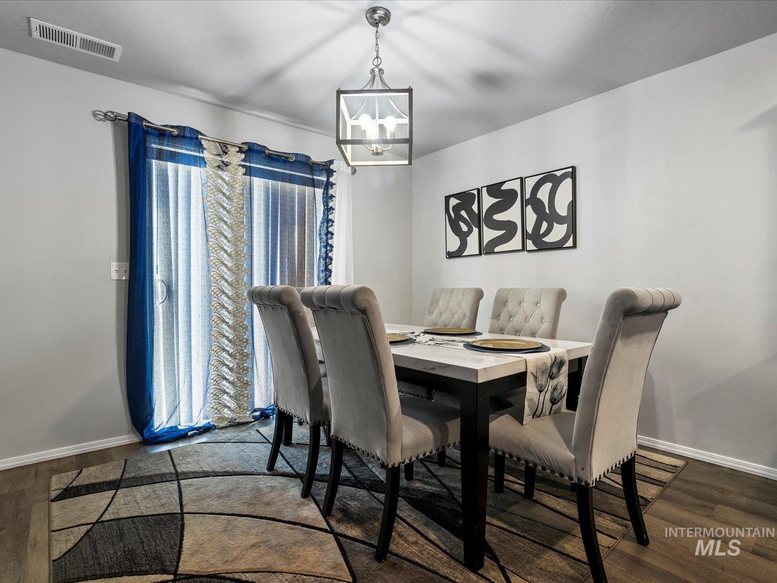 Dining area with wood finished floors and a chandelier