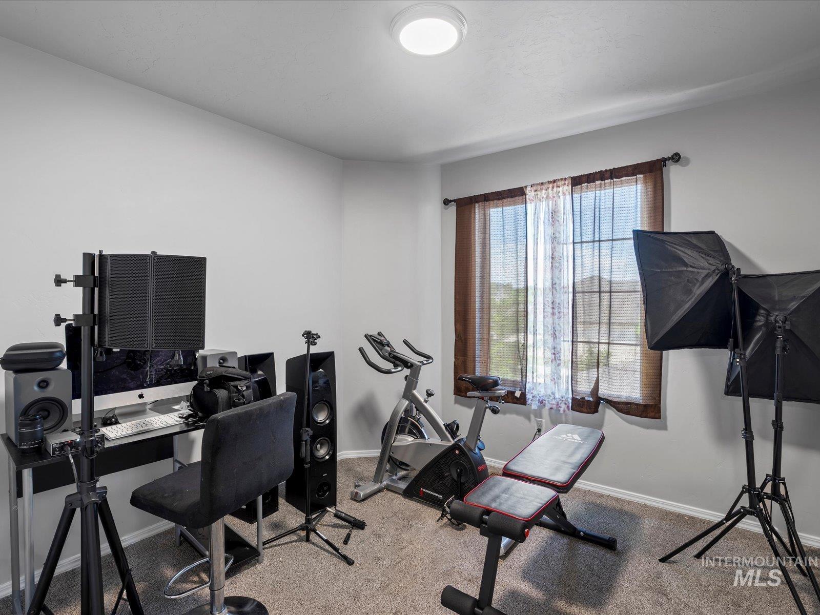 Carpeted home office featuring baseboards