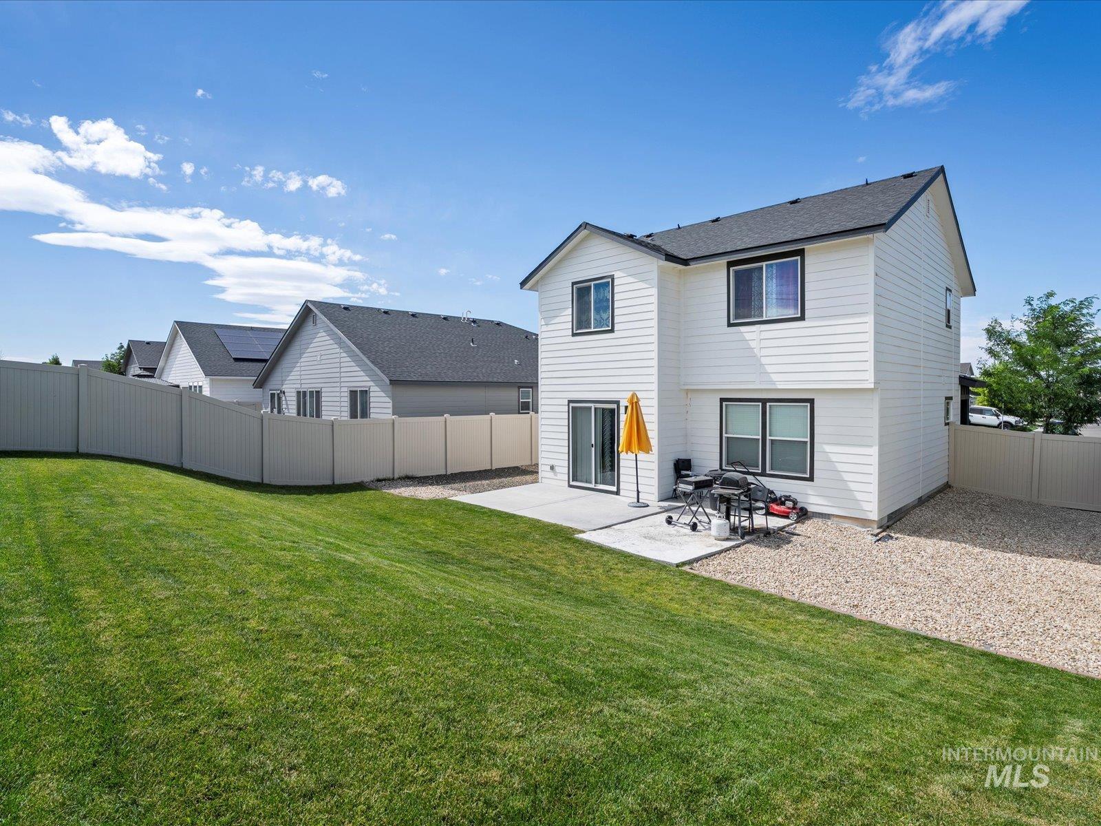 Rear view of house featuring a patio area and a fenced backyard