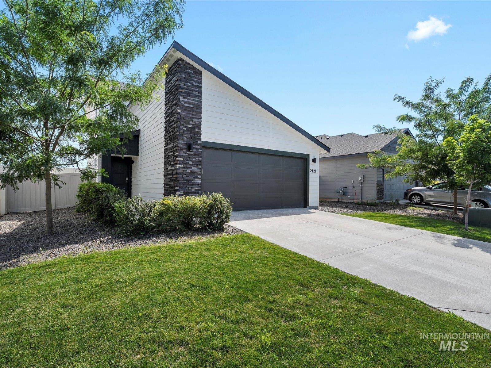 View of front facade with concrete driveway, a front lawn, and a garage