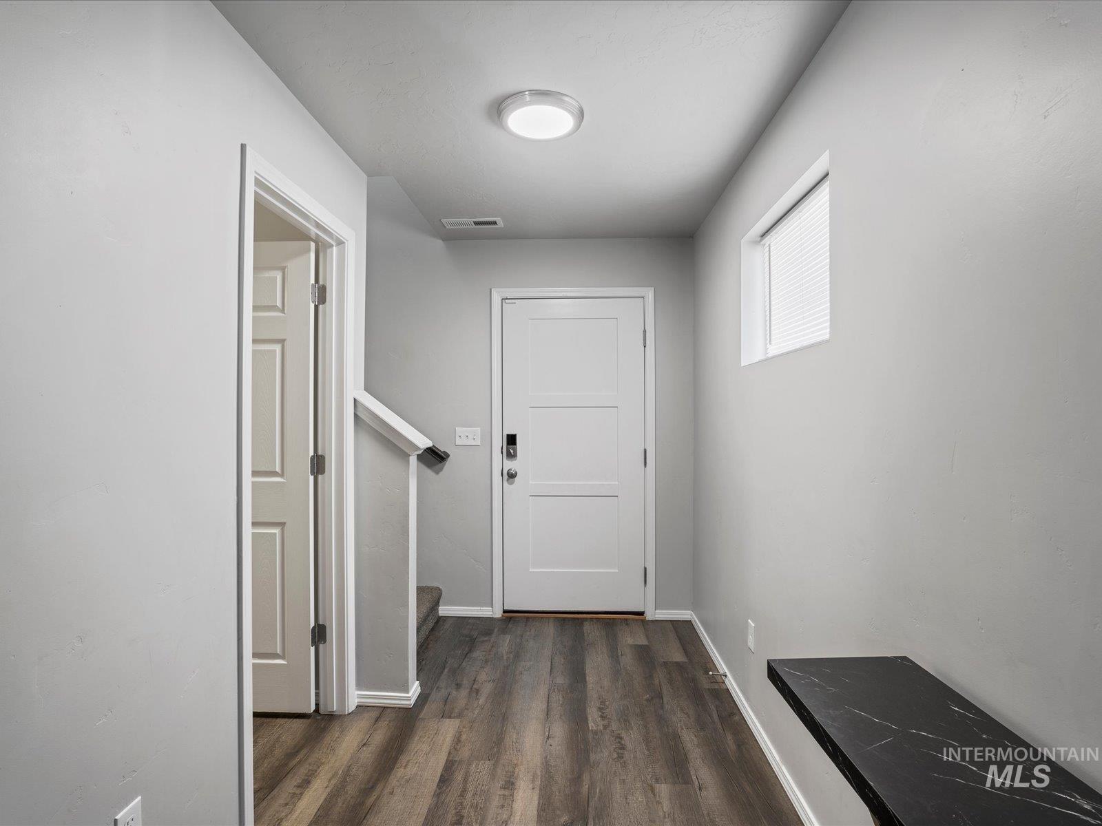 Hallway featuring wood finished floors and stairway