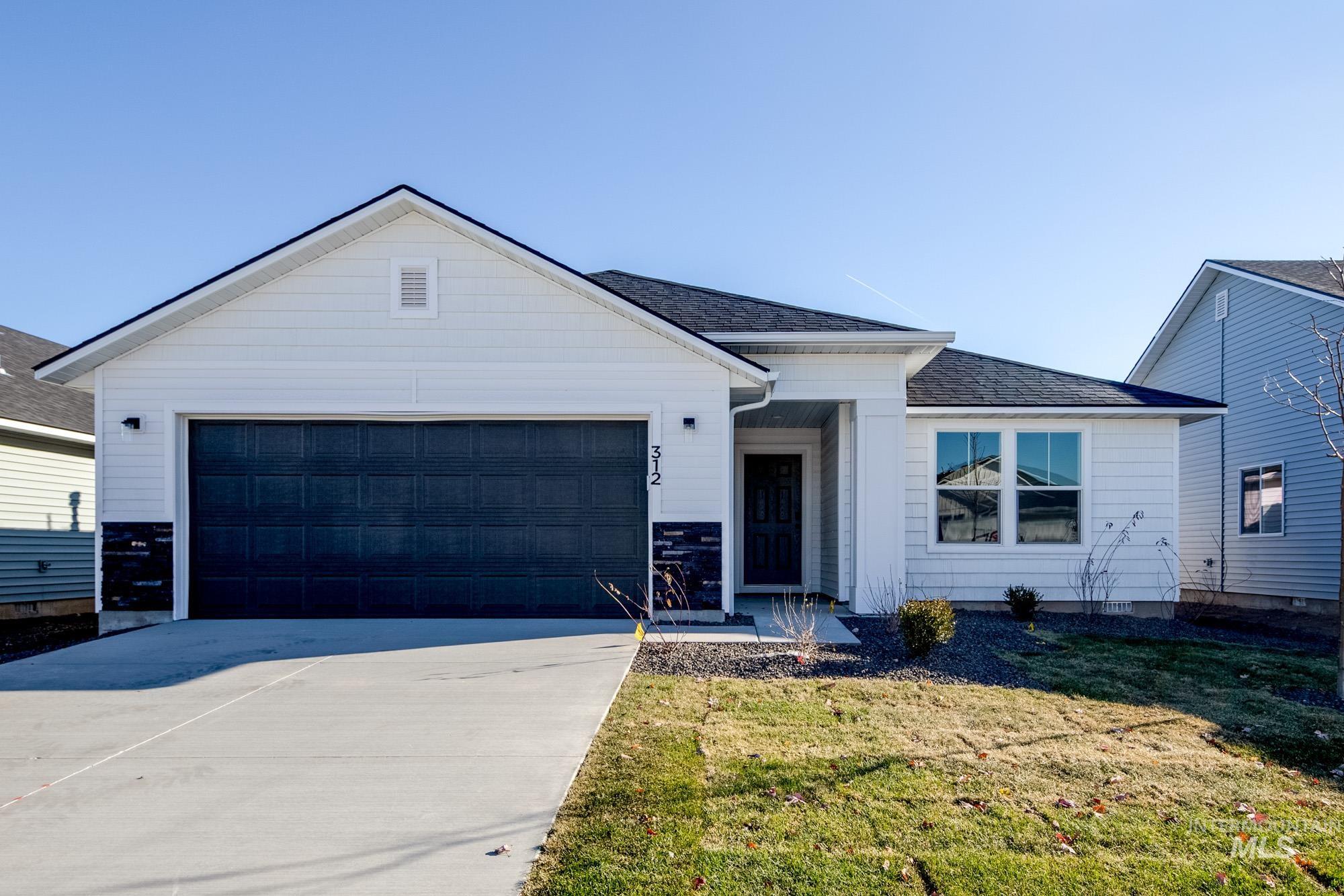 View of front of home featuring a shingled roof, driveway, a front yard, and a garage