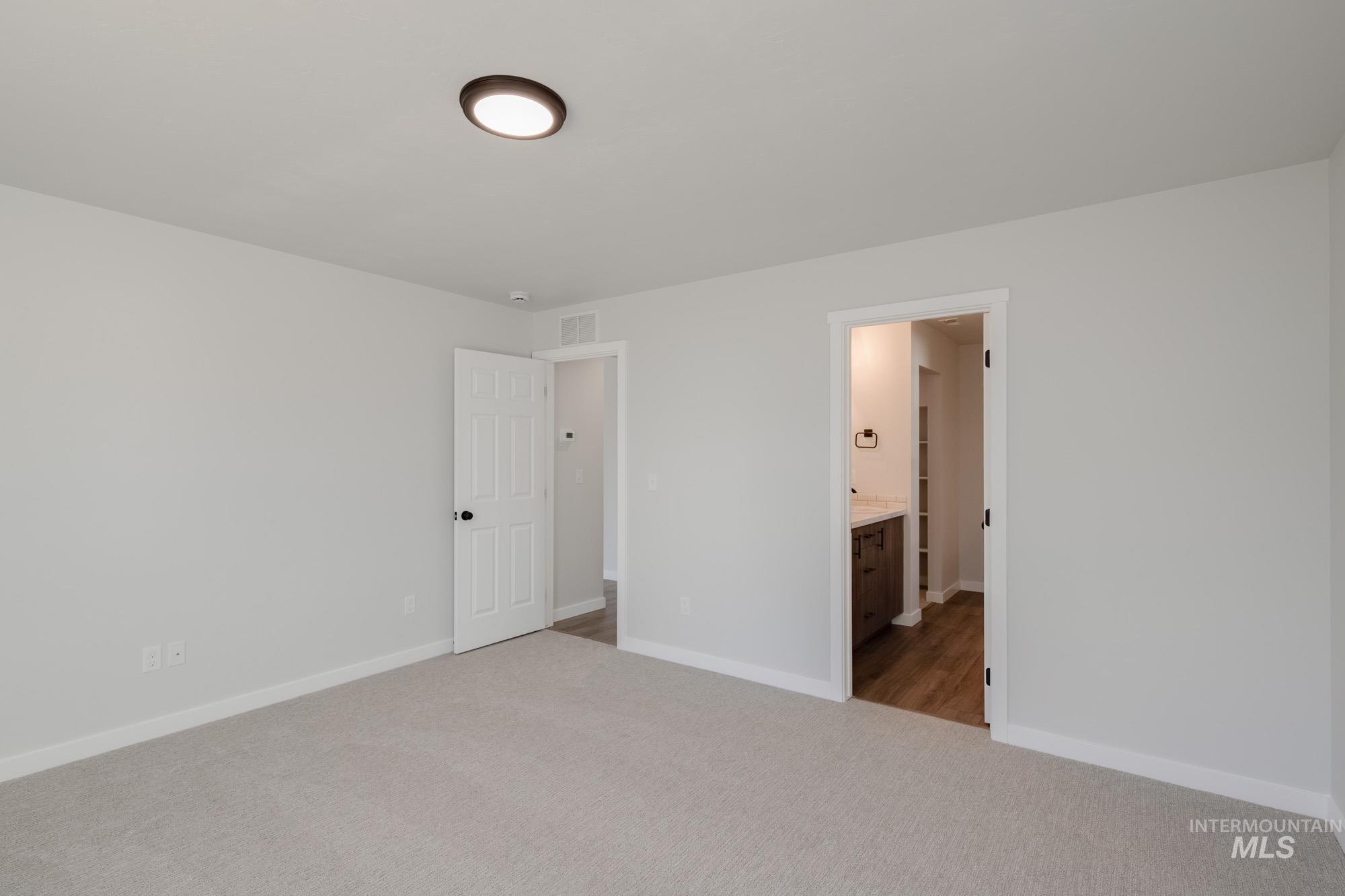 Unfurnished bedroom with carpet floors and connected bathroom