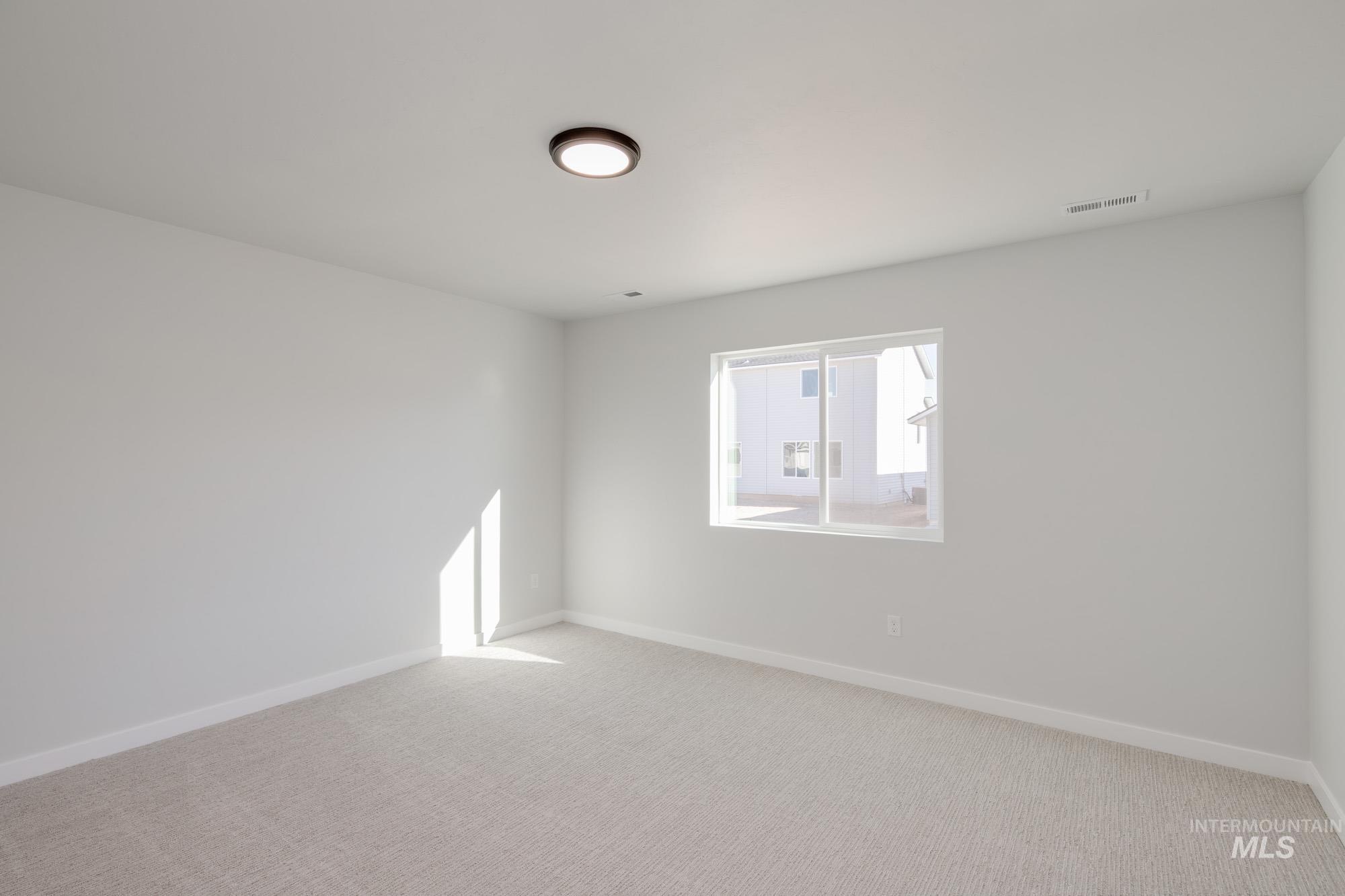 Spare room featuring baseboards and light colored carpet