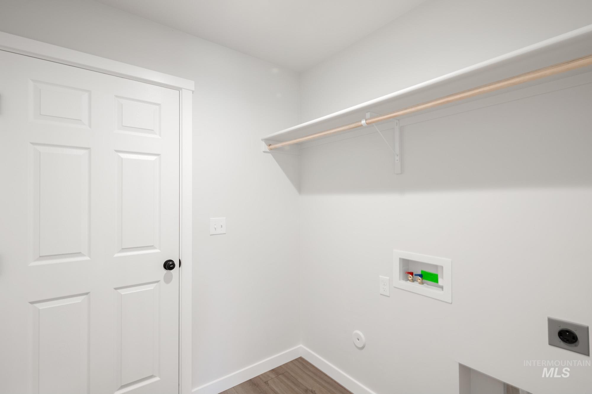 Laundry area featuring hookup for a washing machine, light wood-style floors, and electric dryer hookup
