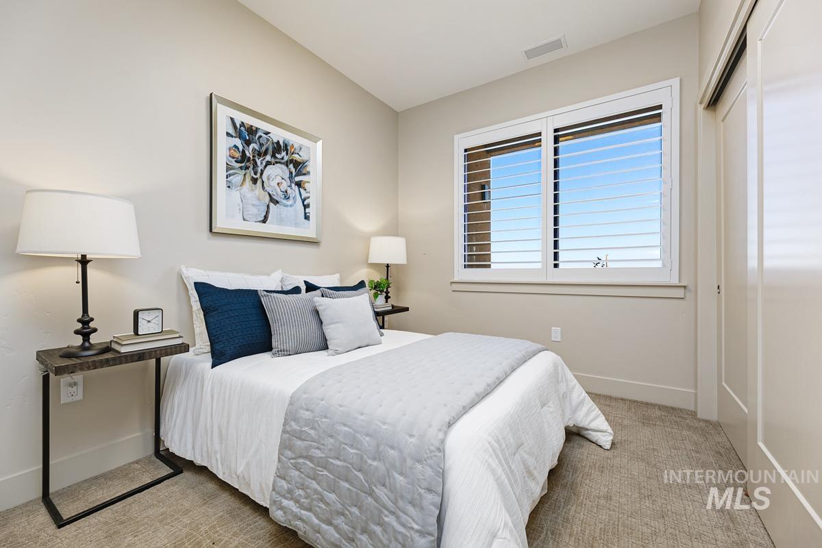 Bedroom featuring light colored carpet and a closet