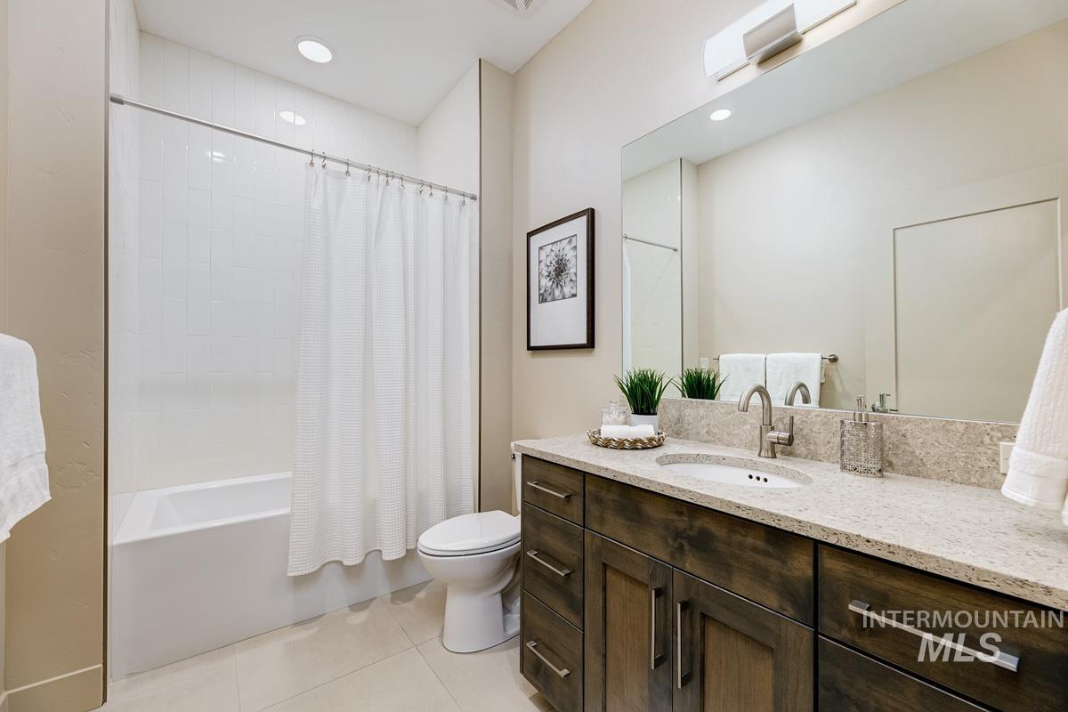 Full bath with shower / bath combination with curtain, vanity, light tile patterned floors, and recessed lighting