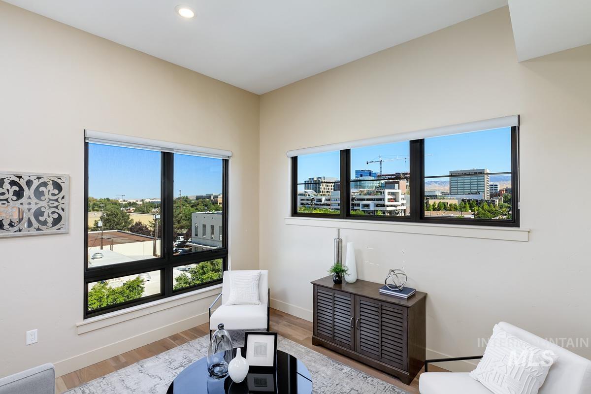 Living area featuring plenty of natural light, wood finished floors, a view of city, and recessed lighting