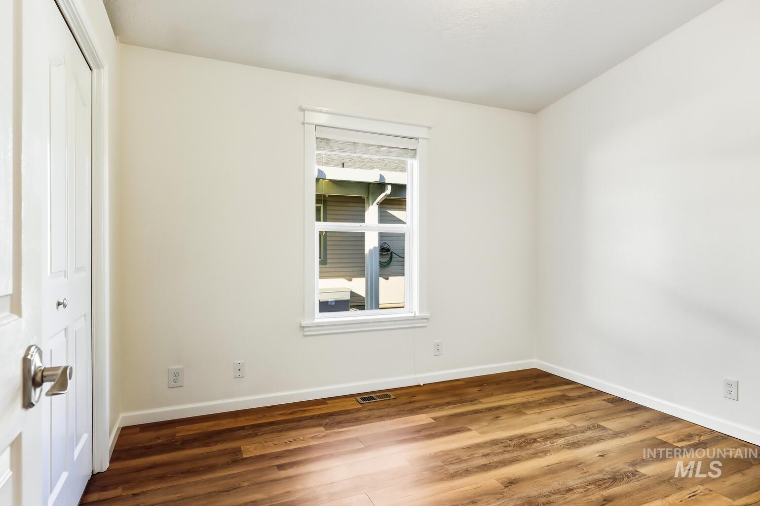 Unfurnished bedroom with wood finished floors and a closet