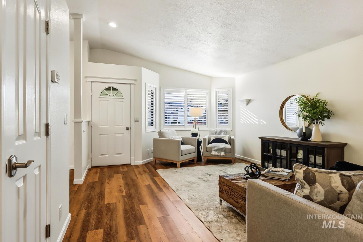 Foyer entrance with vaulted ceiling and wood finished floors