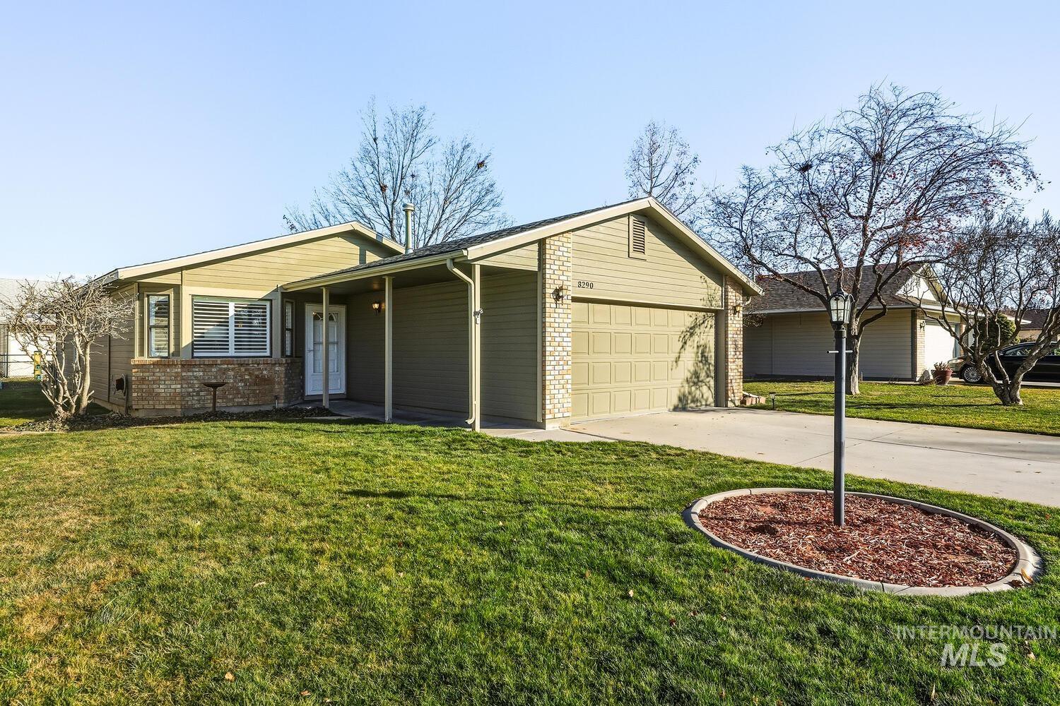 Single story home featuring brick siding, a front yard, concrete driveway, and a garage