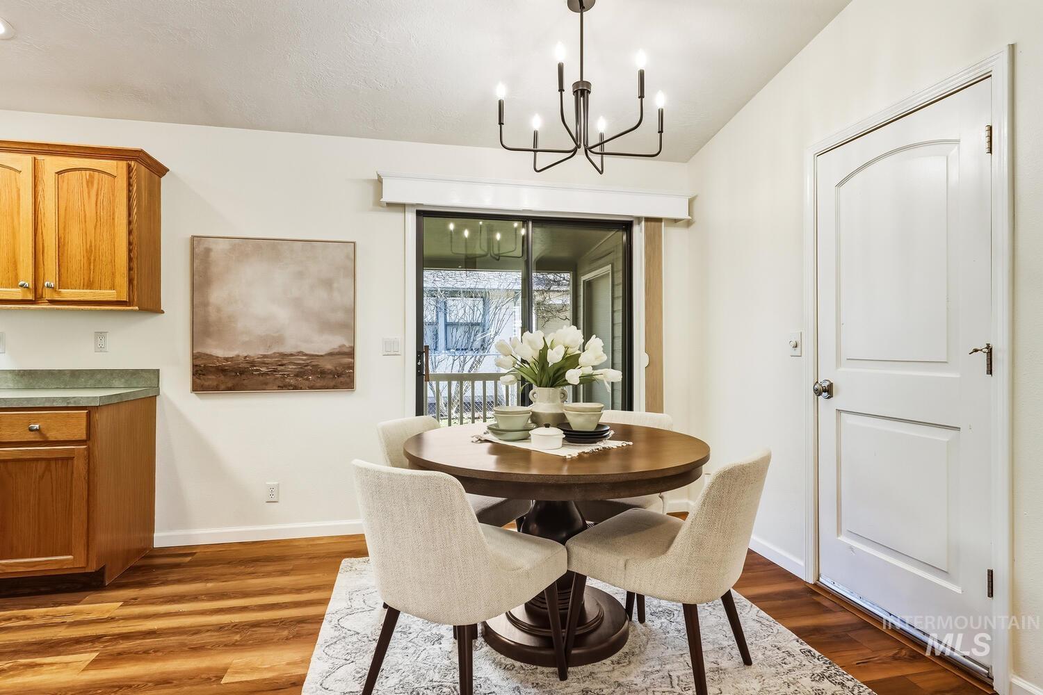 Dining area with dark wood finished floors and suspended lighting