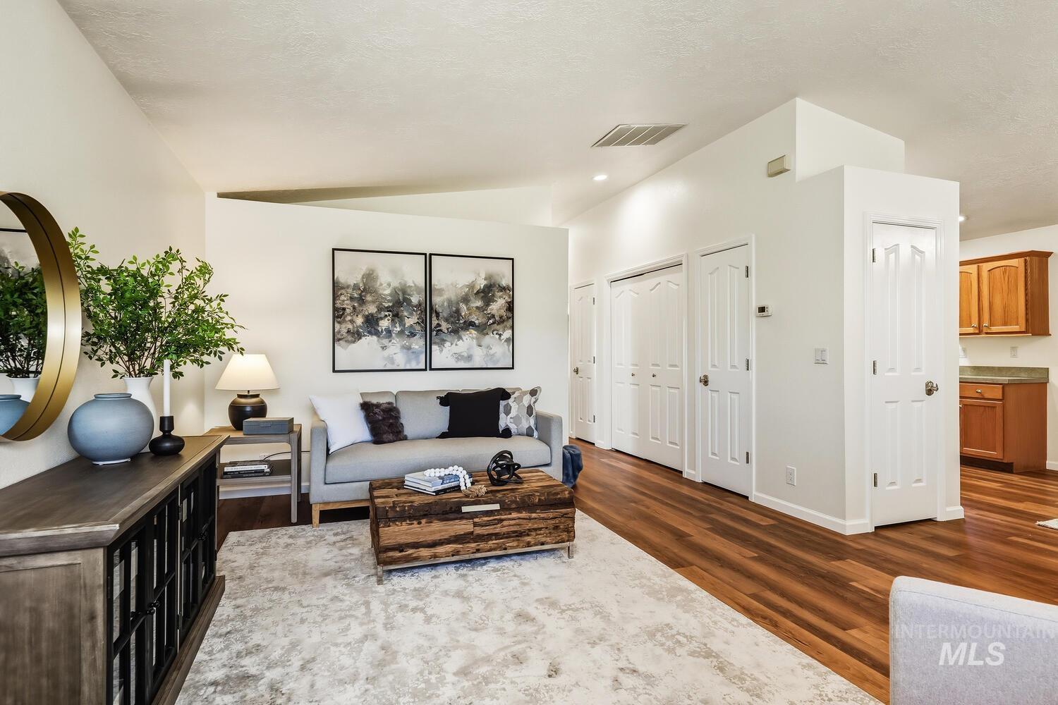 Living room with dark wood-style floors and vaulted ceiling
