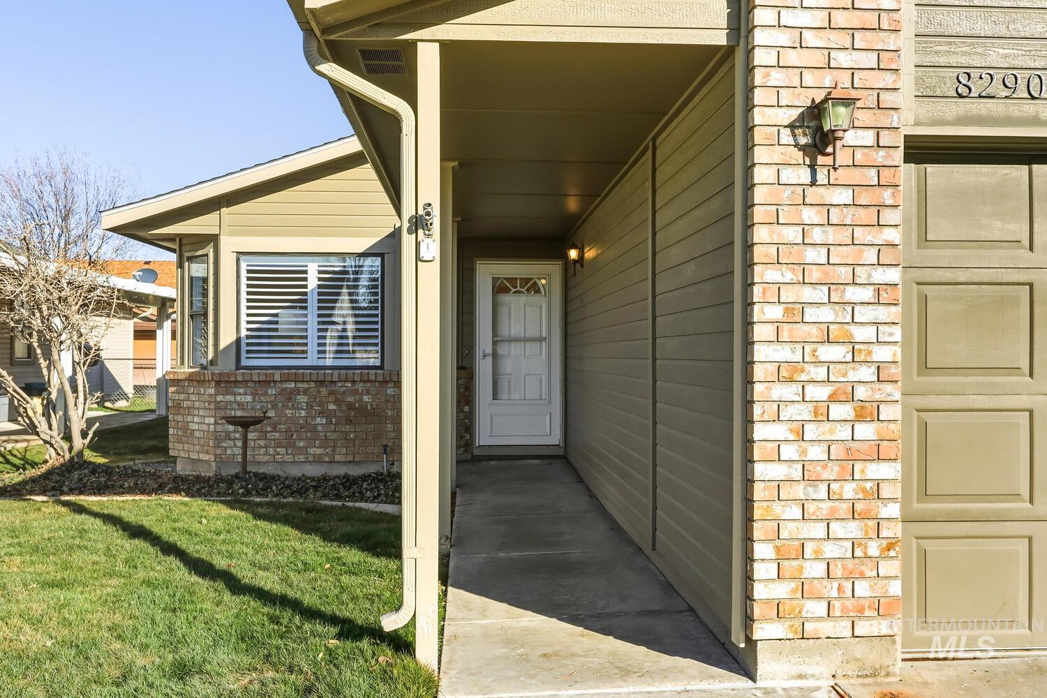 Property entrance with brick siding and a yard