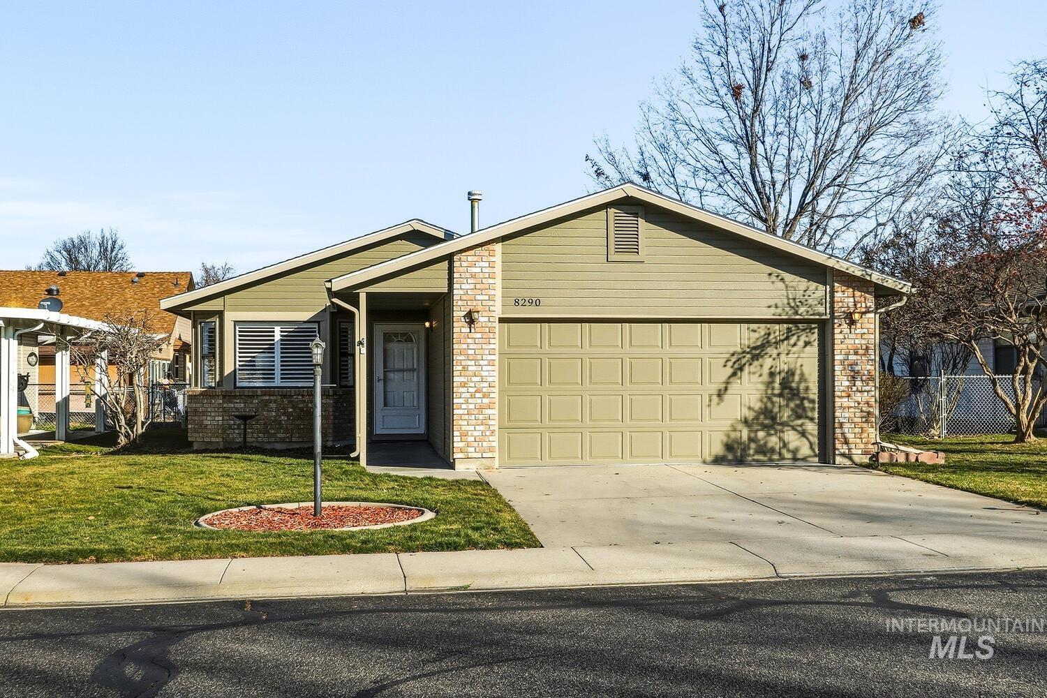 View of front of property with concrete driveway, brick siding, and an attached garage