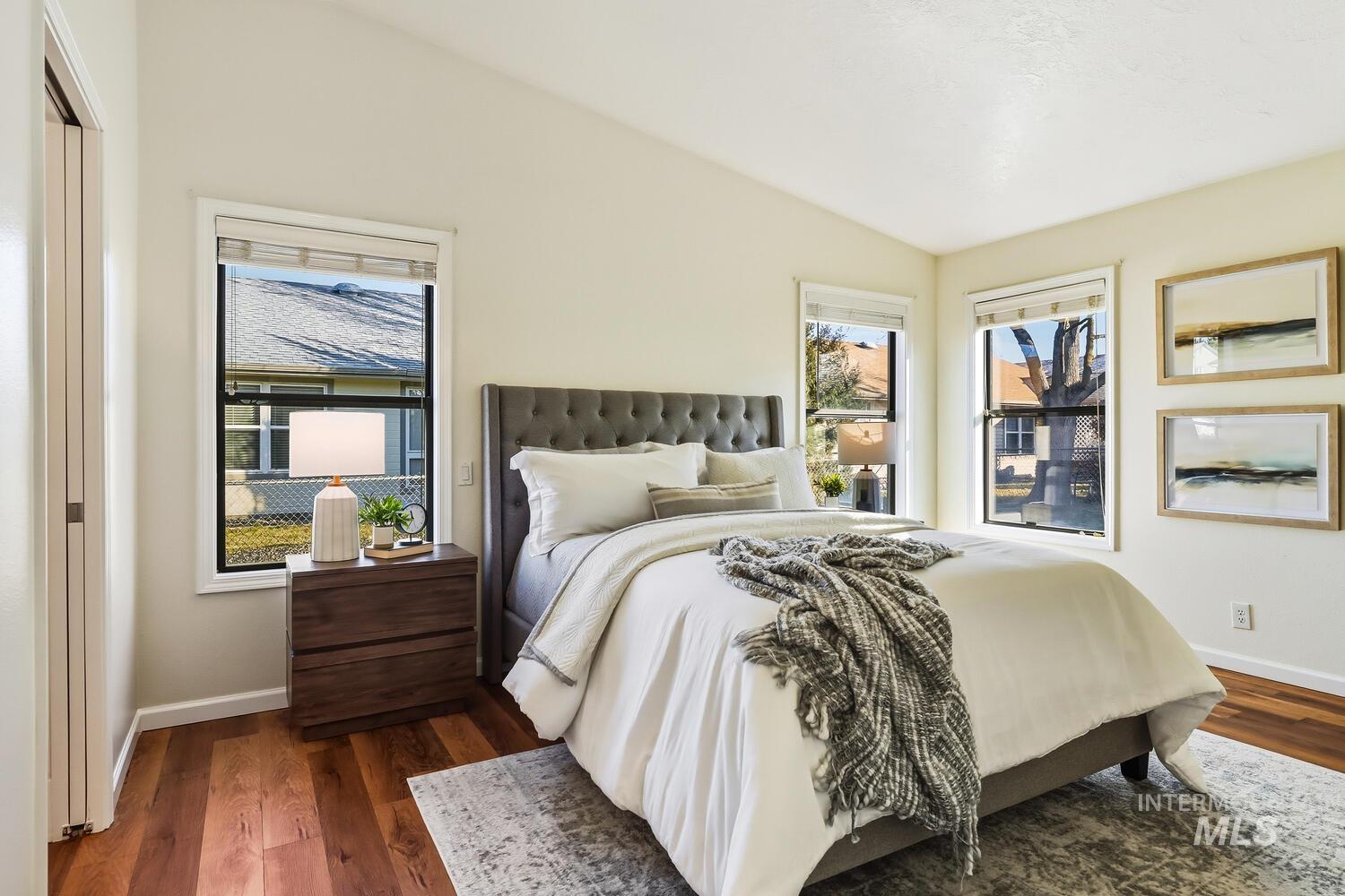 Bedroom featuring dark wood-style flooring and lofted ceiling