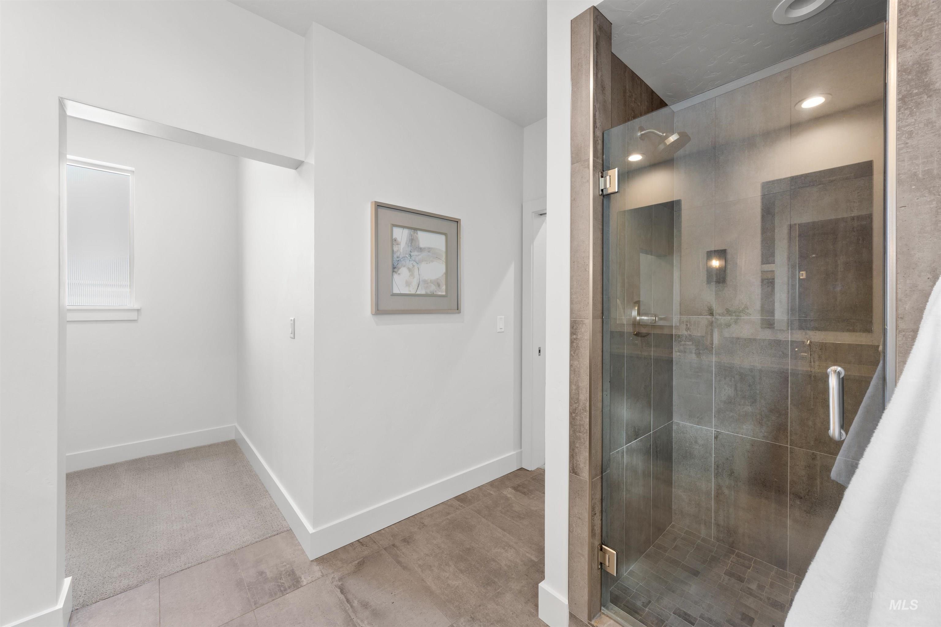 Bathroom featuring a stall shower and baseboards