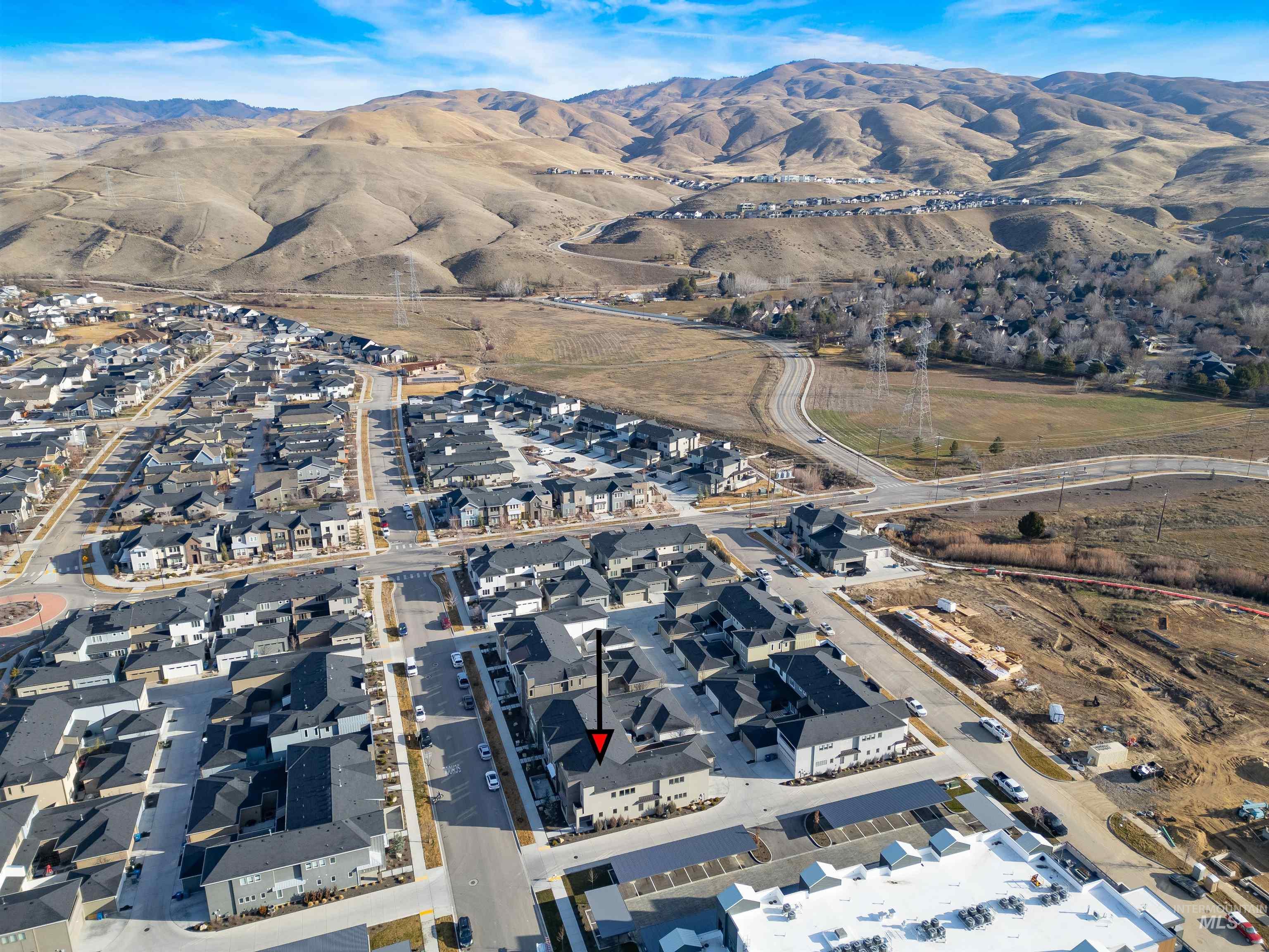 Aerial overview of property's location featuring a mountain backdrop and nearby suburban area