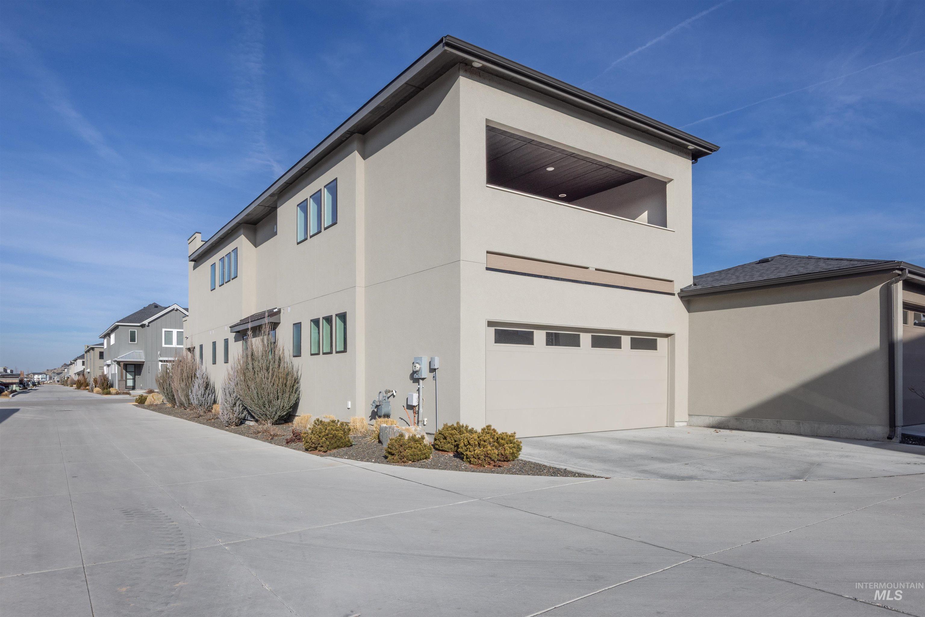 View of home's exterior featuring stucco siding, an attached garage, and concrete driveway