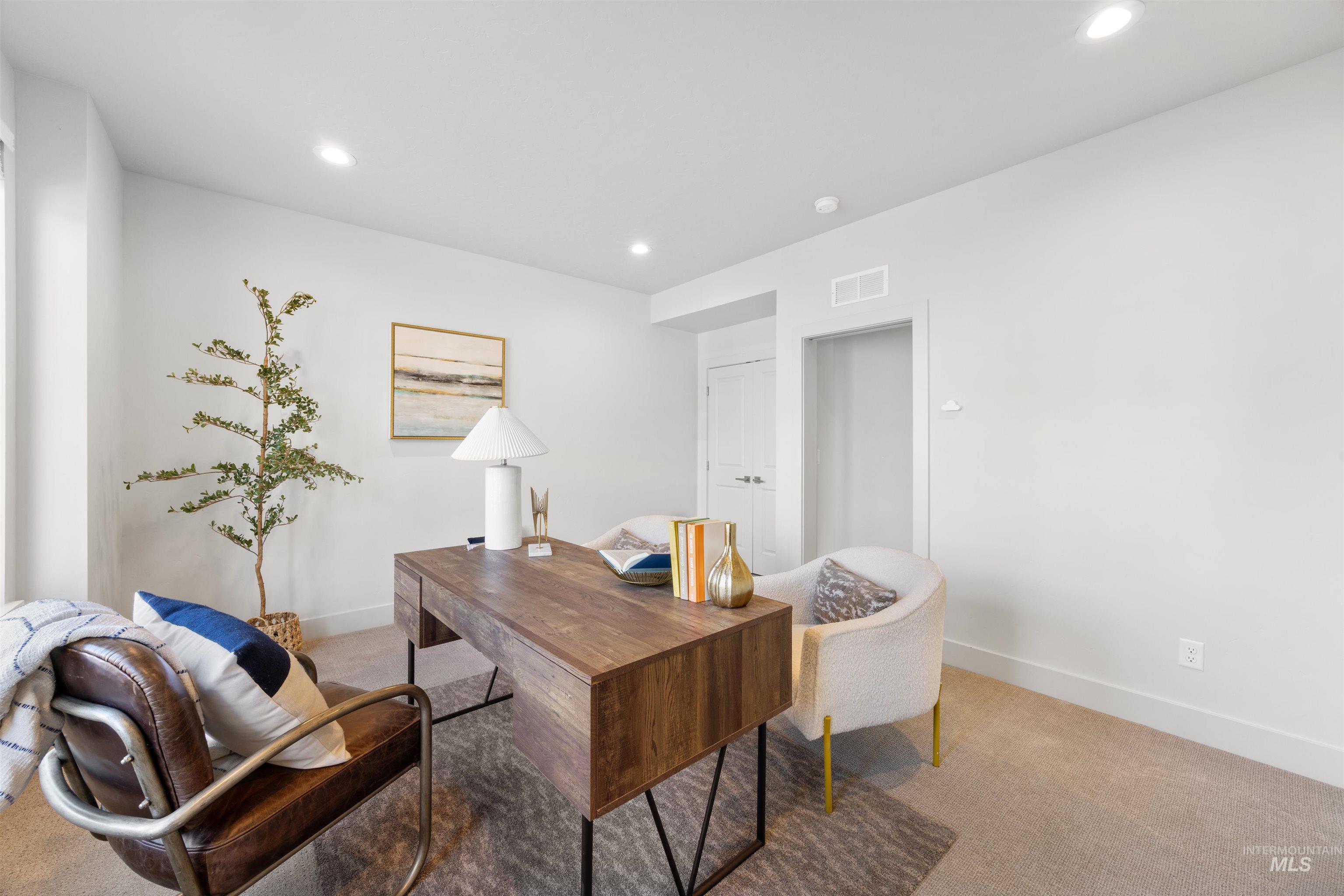 Carpeted office space with baseboards and recessed lighting