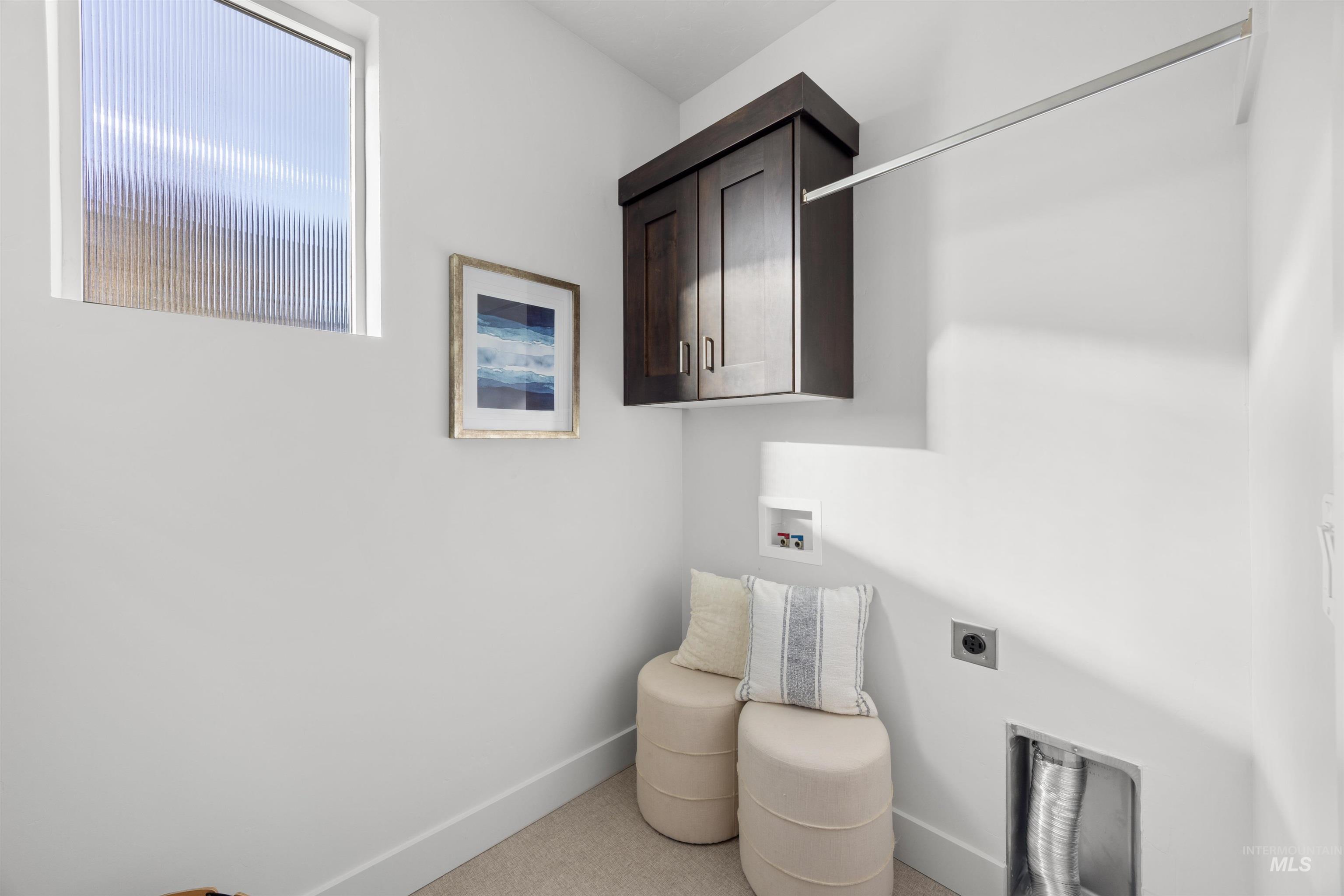 Laundry area featuring hookup for a washing machine, electric dryer hookup, and cabinet space