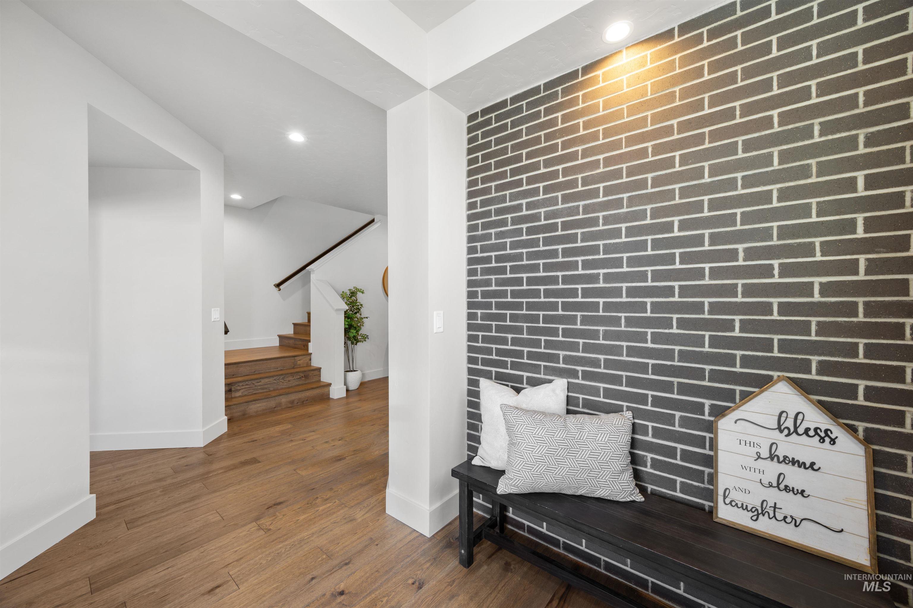 Sitting room featuring recessed lighting, dark wood finished floors, brick wall, and an accent wall