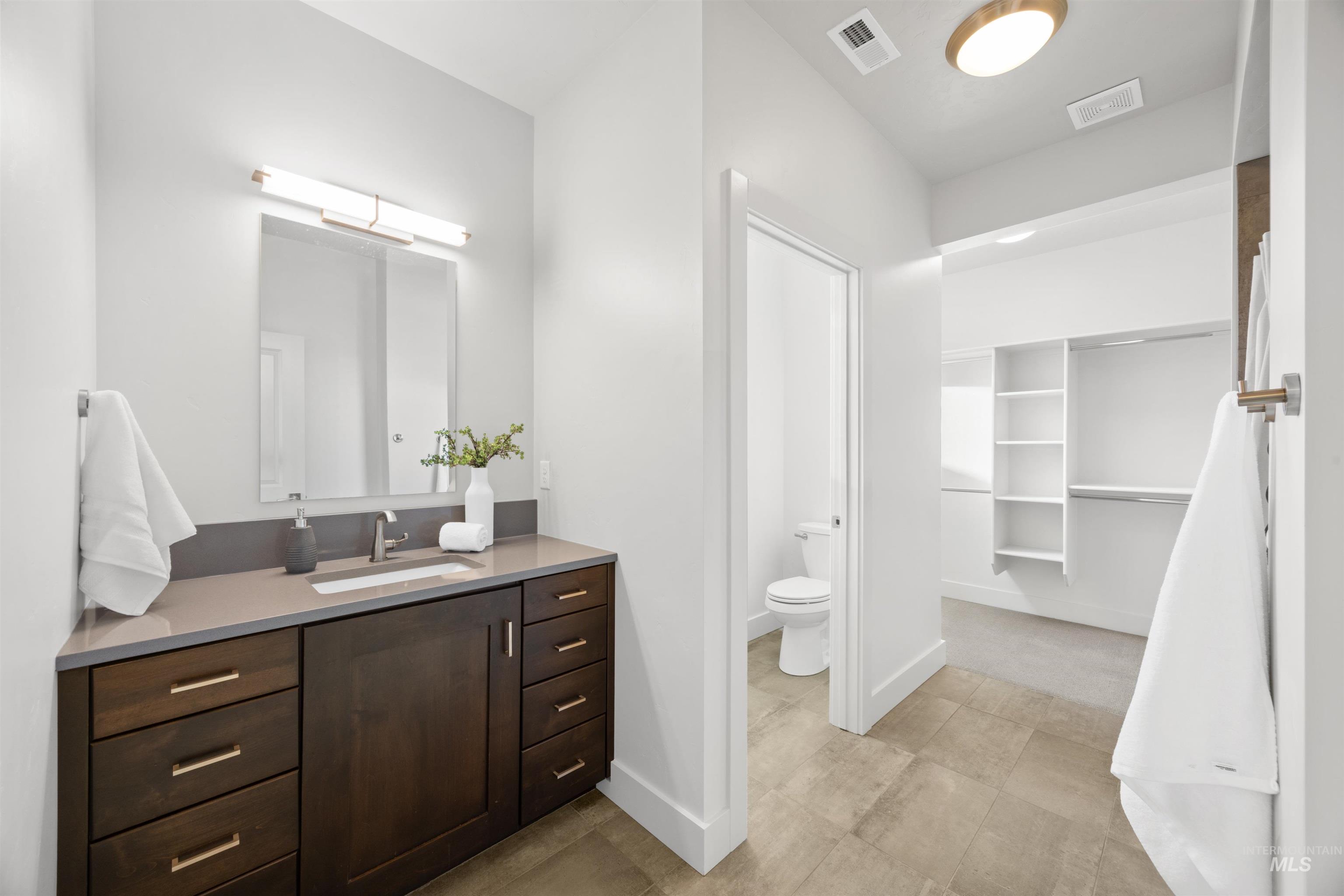 Full bathroom featuring vanity and a spacious closet
