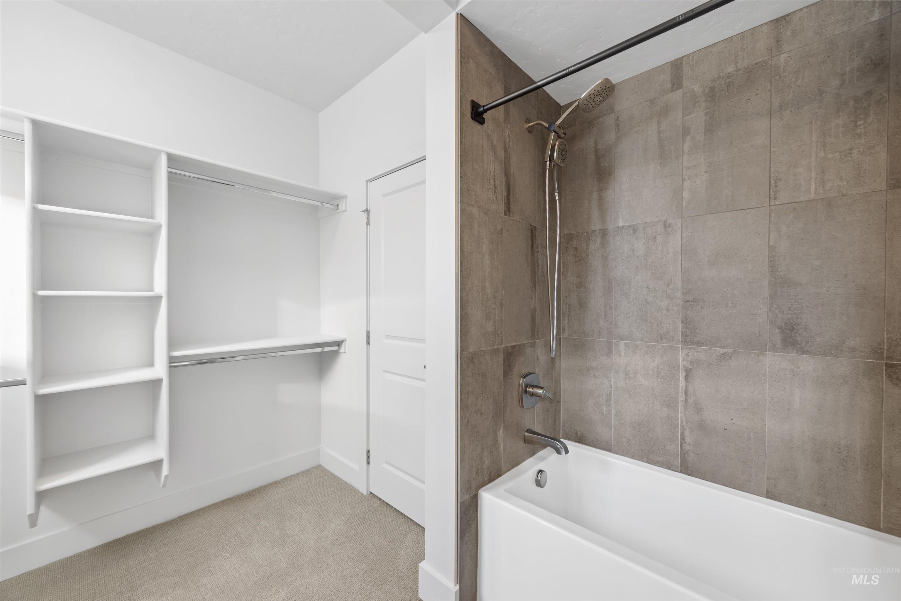 Bathroom with shower / bathtub combination and light carpet