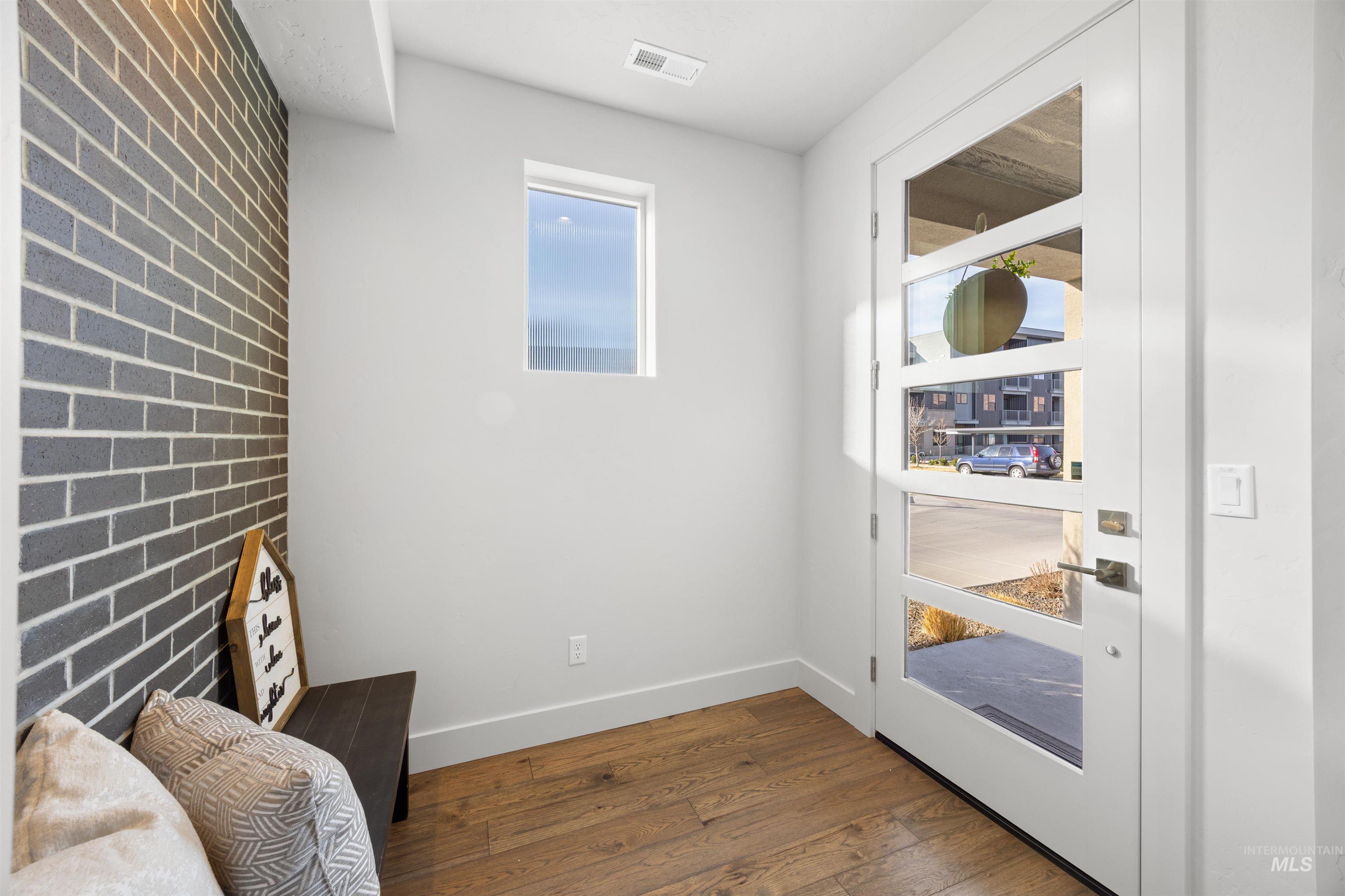 Living area featuring dark wood-type flooring and brick wall