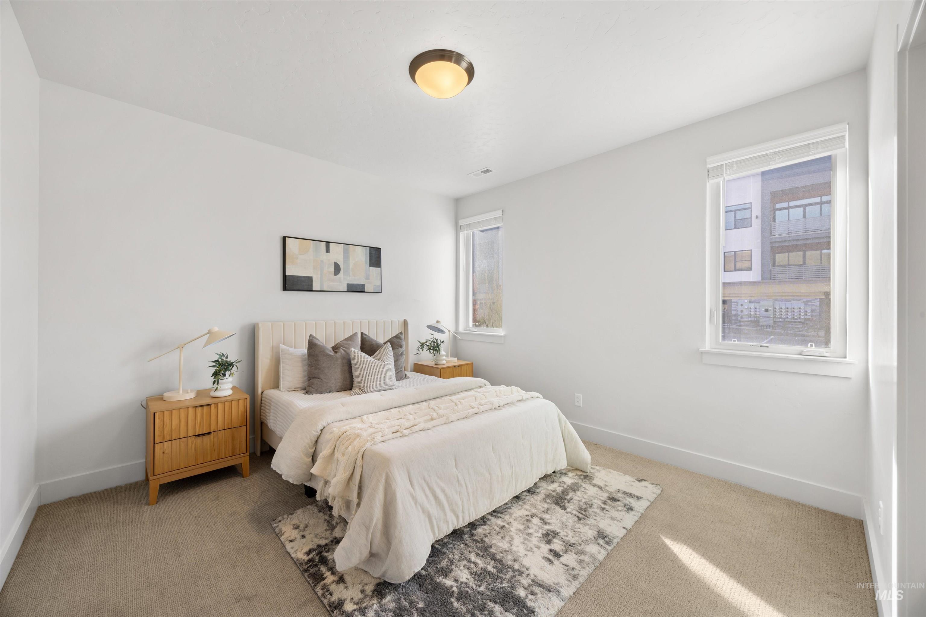 Bedroom with light colored carpet and baseboards