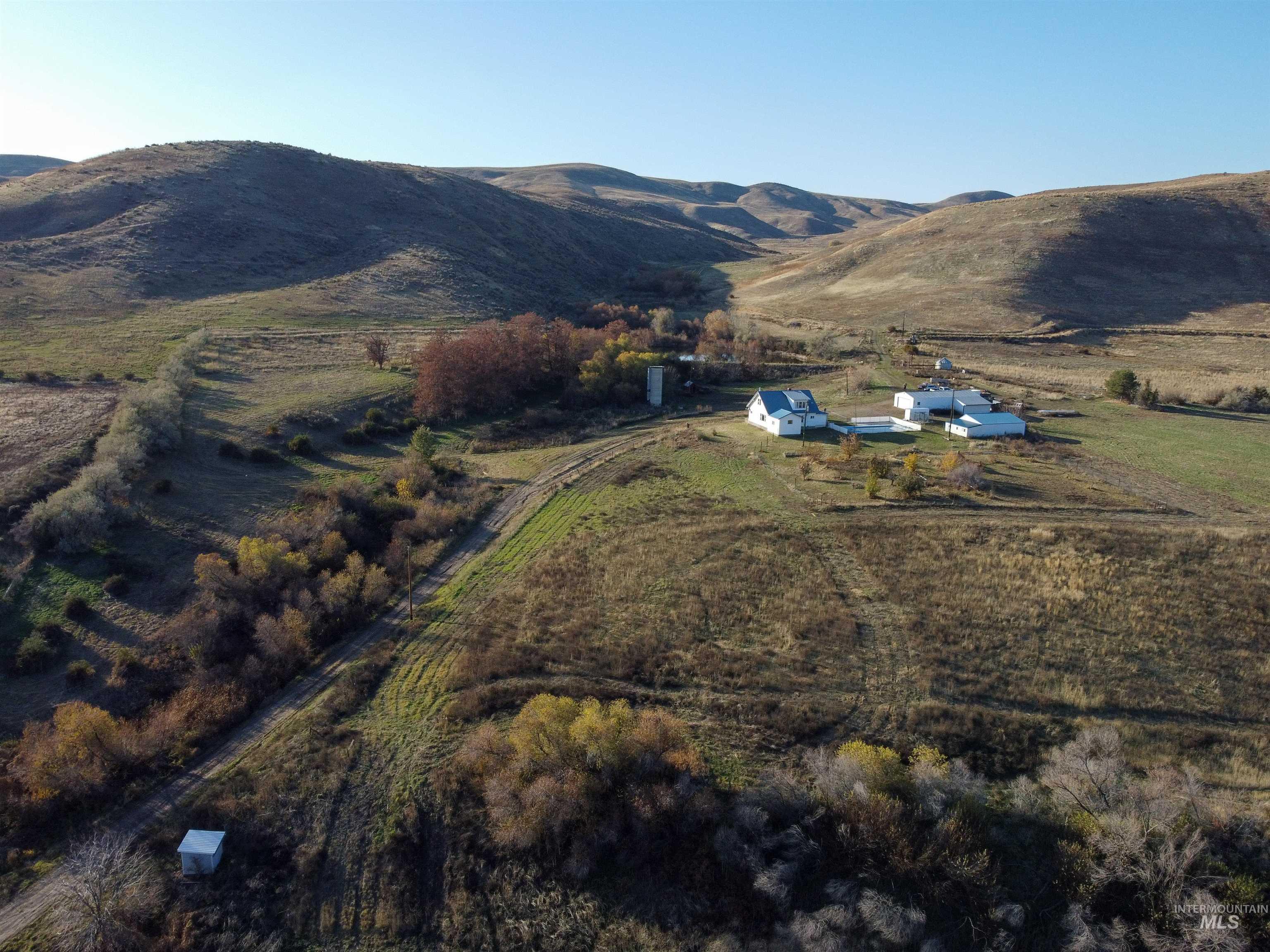 Aerial view of property and surrounding area with a mountain backdrop and rural landscape