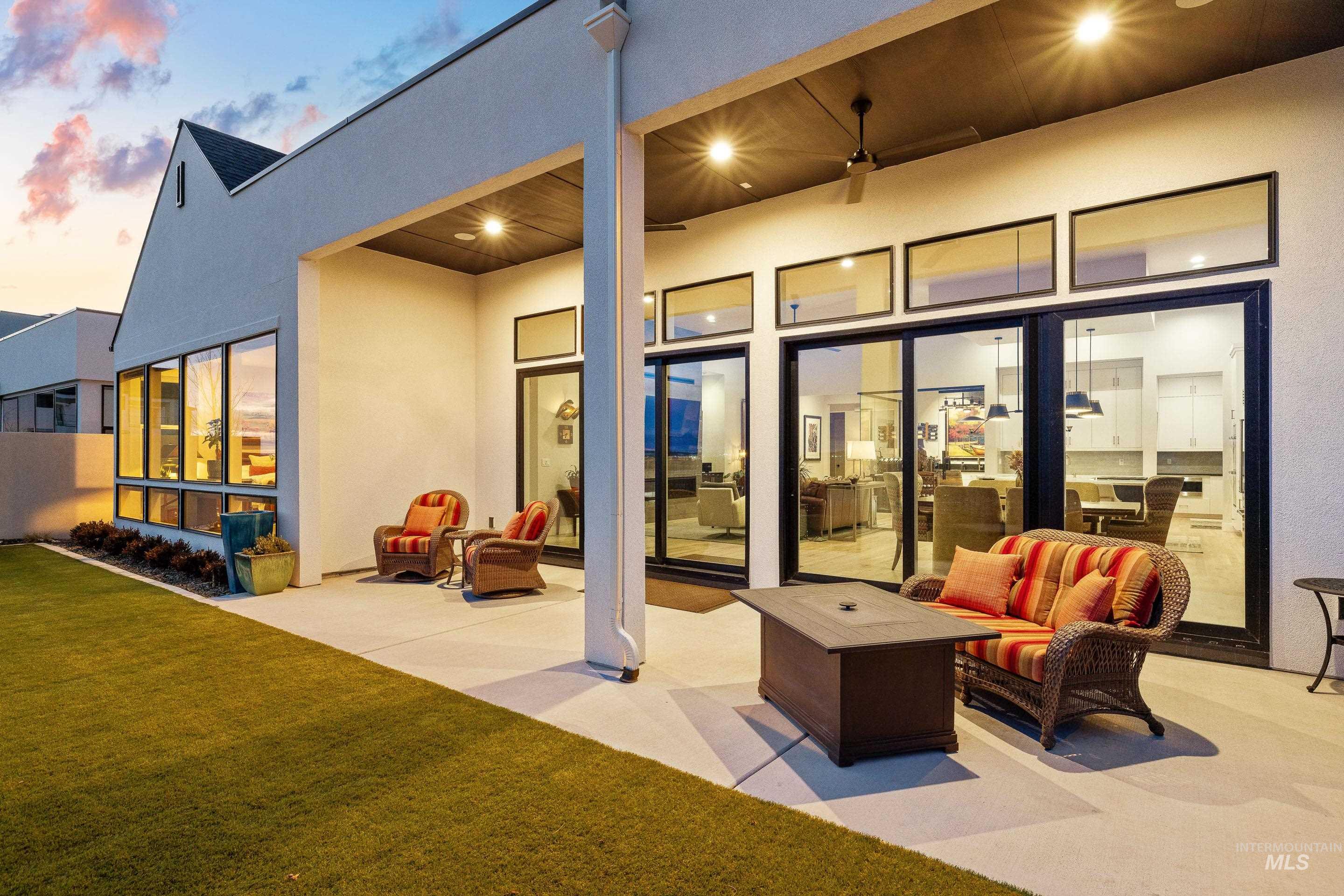 Rear view of house with an outdoor living space, a patio area, stucco siding, and a yard