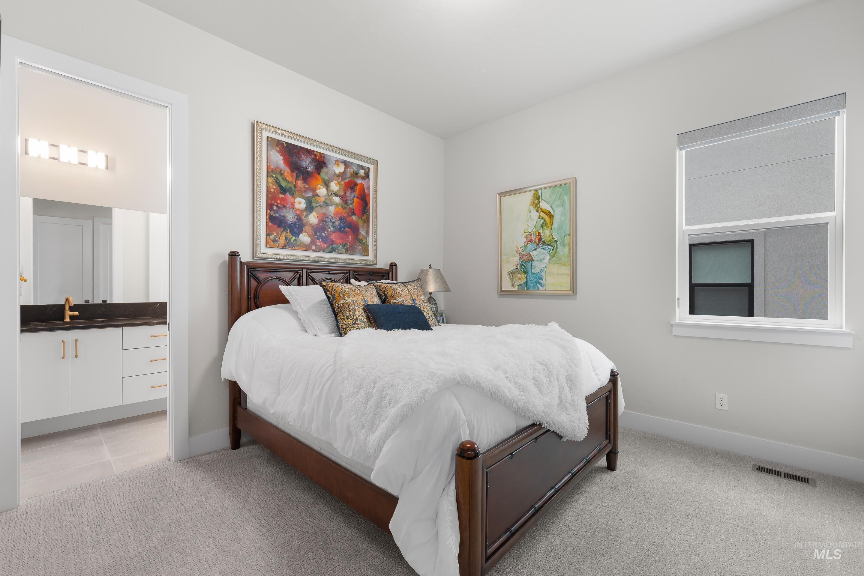 Bedroom with light colored carpet and ensuite bath