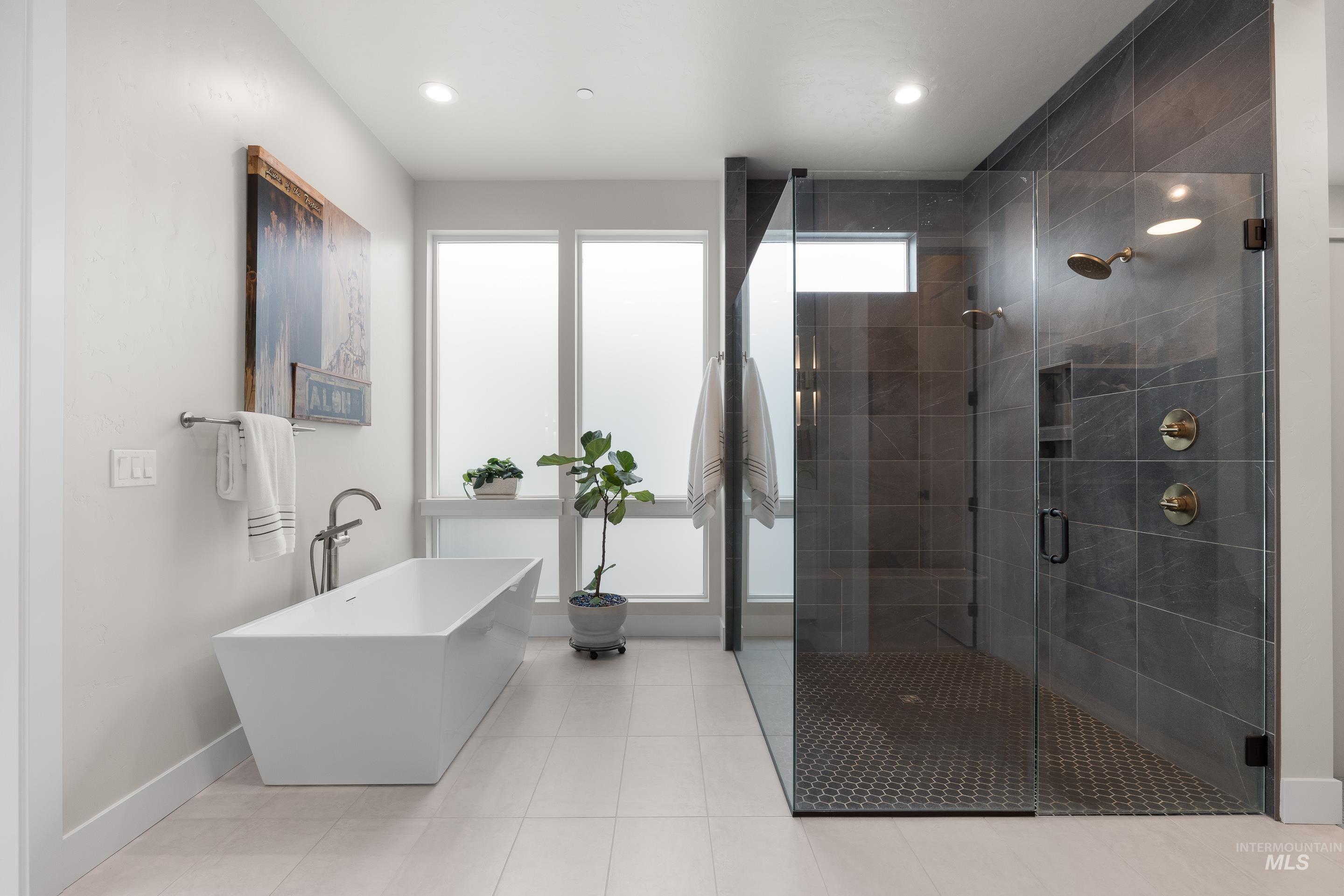 Full bath featuring a freestanding tub, a stall shower, light tile patterned floors, and recessed lighting