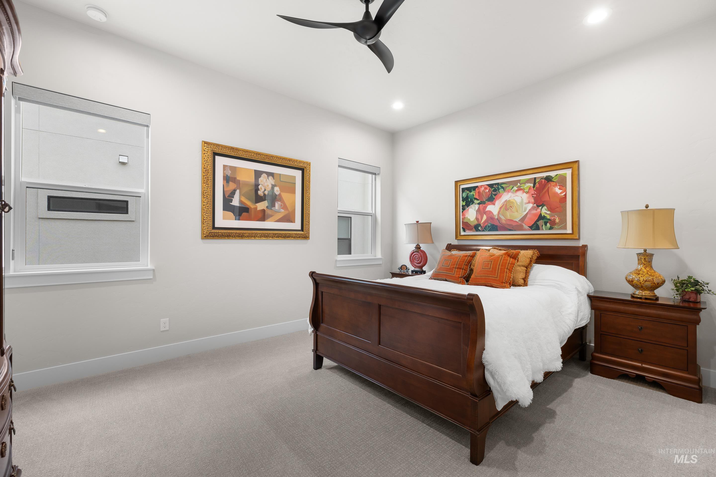 Carpeted bedroom with a ceiling fan and recessed lighting